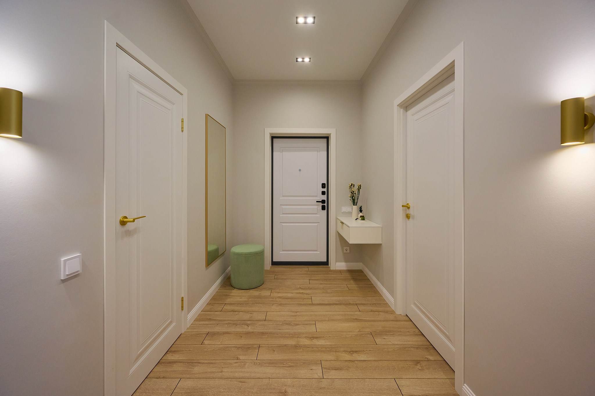коридор светлых тонов белые двери белый столик зеркало зеленый пуфик 
