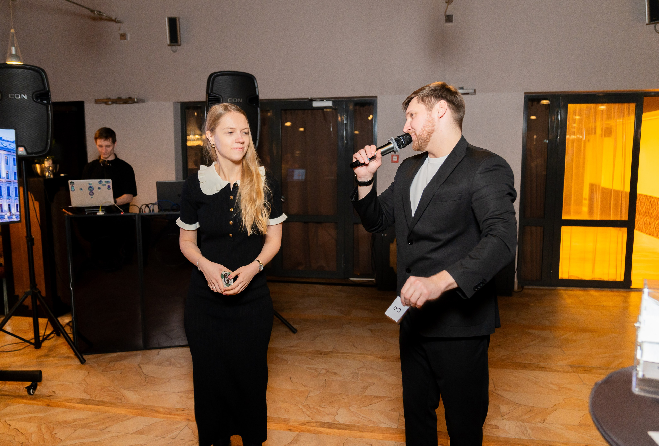 Ведущий интервьюирует участницу розыгрыша на мероприятии в Radisson Sonya. Девушка держит выигрышный номер 3. Фото Евгения Мальцева (evrednix.ru).