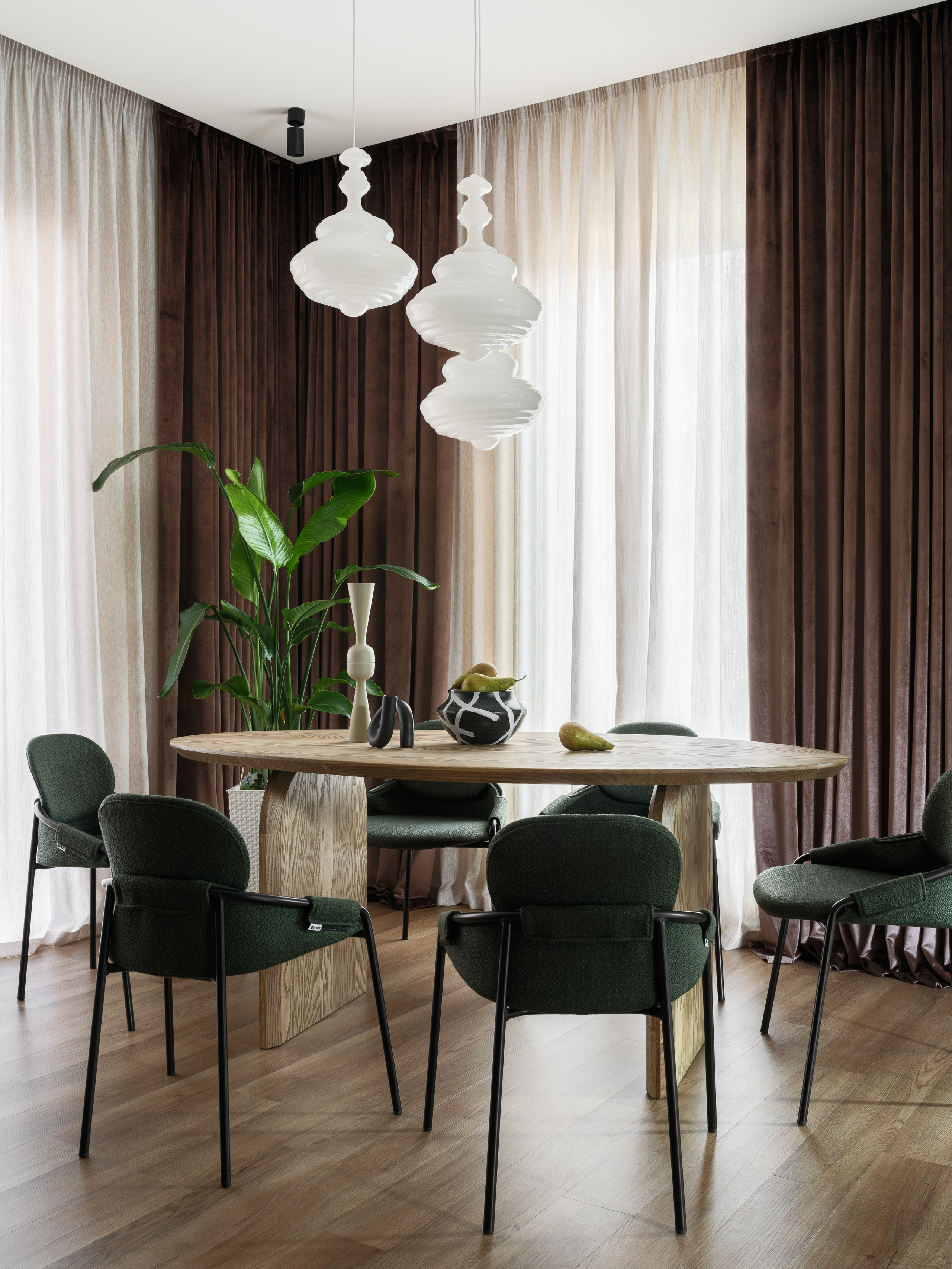 Элегантная столовая зона с деревянным столом и дизайнерскими светильниками. Гармония зелёных текстур и натуральных материалов в проекте Наталии Шелепниковой, запечатлённом Сергеем Денисенко и стилизованном Алёной Бершацкой.