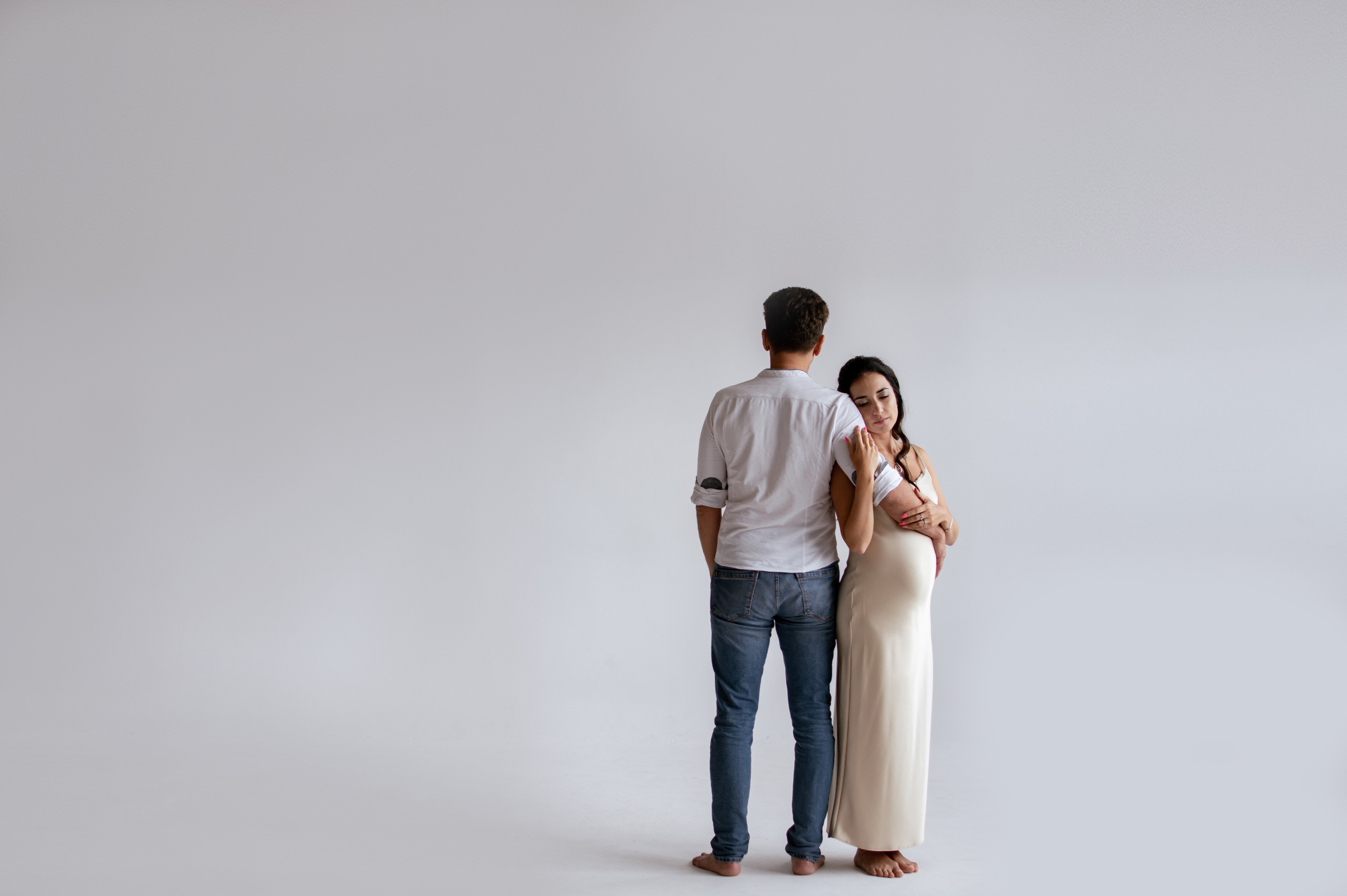 Беременная женщина с мужем на циклораме