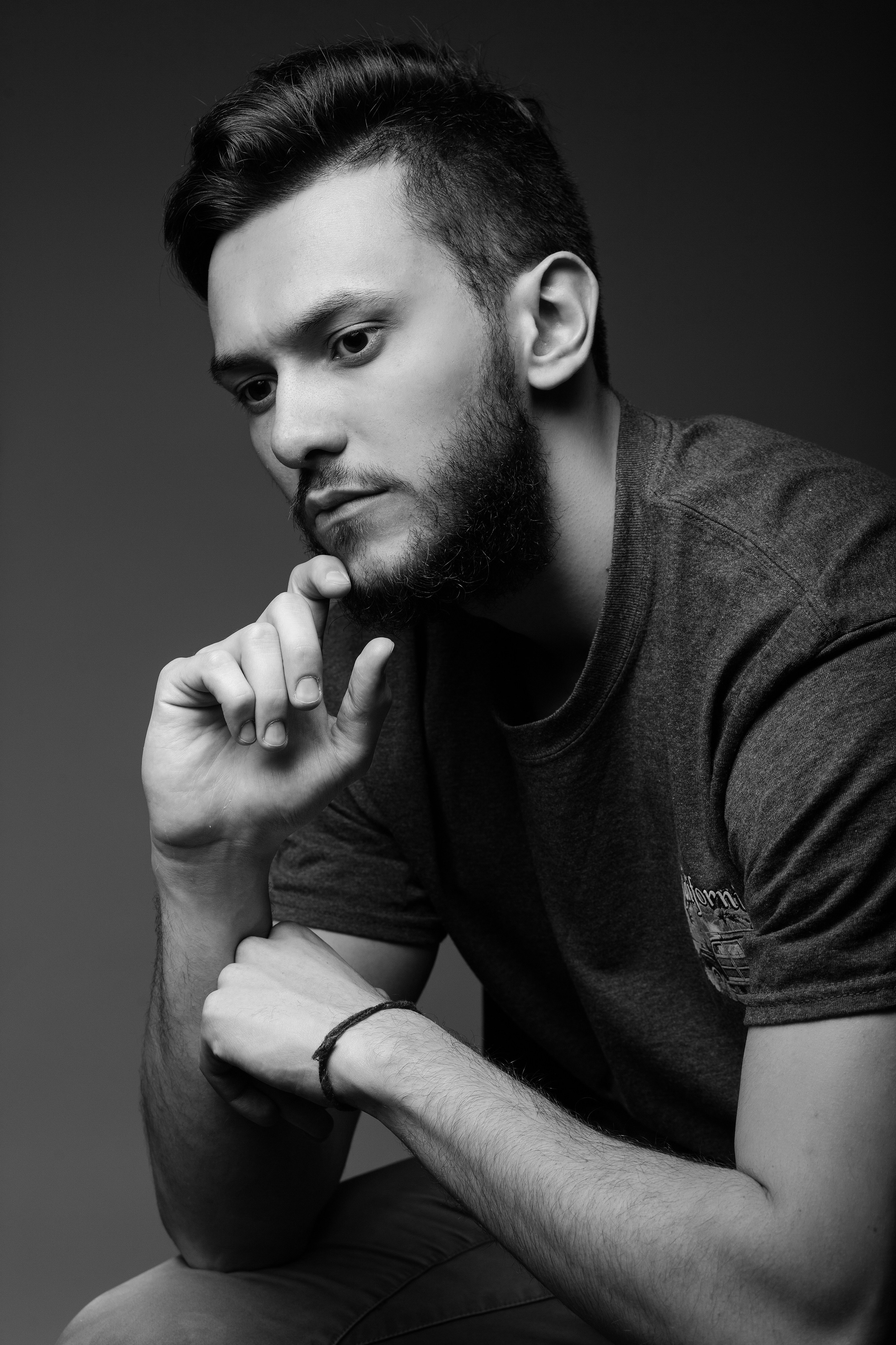 Чёрно-белый мужской портрет задумчивого парня в студии