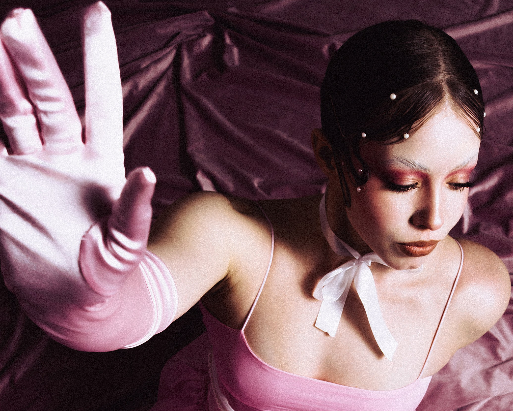 Фотограф Александра Овечкина Пенза: крупный план розовой атласной перчатки, тянущейся к зрителю на фоне глубоких складок бархата.