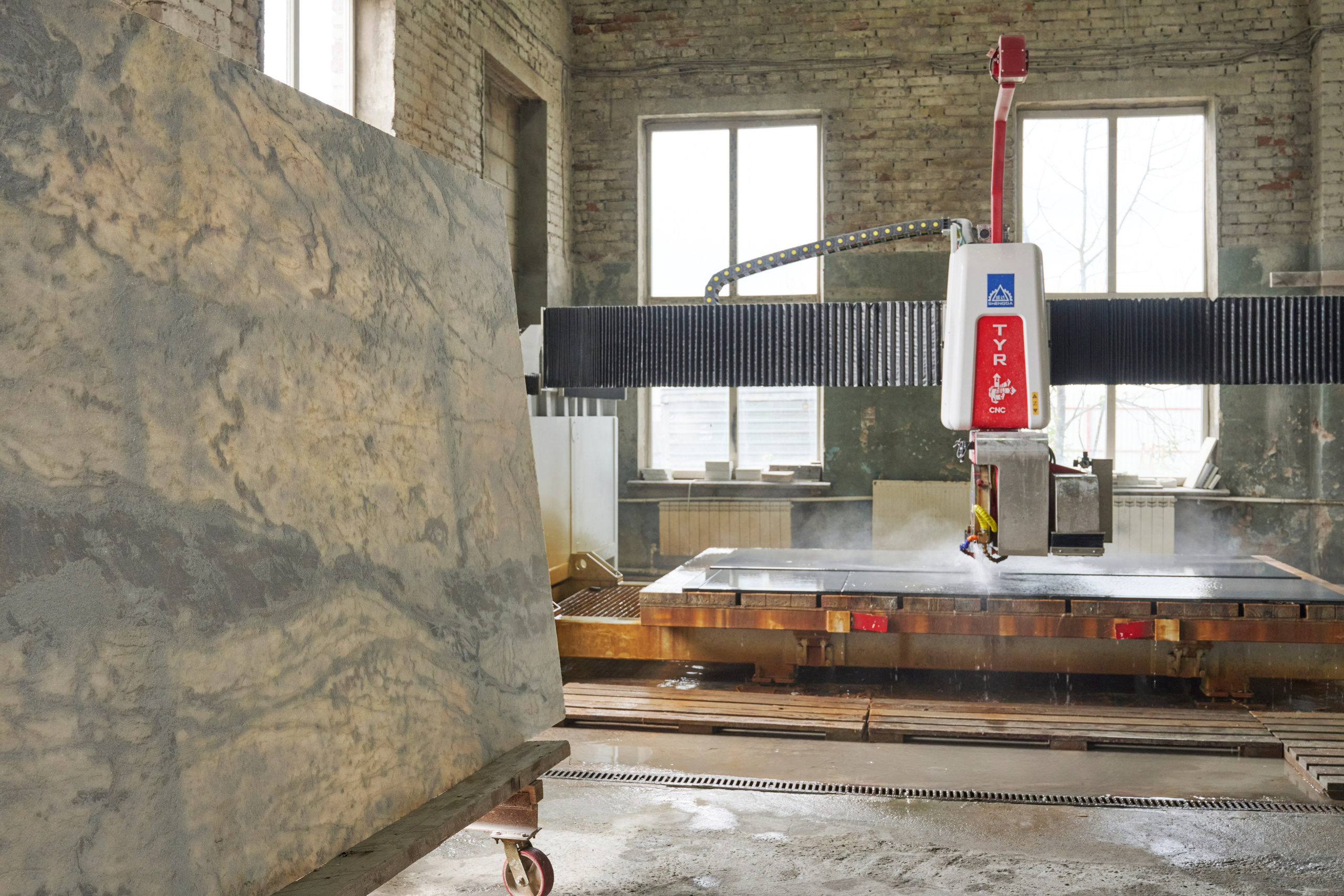 Станок и рабочая зона, плита на столе в цехе