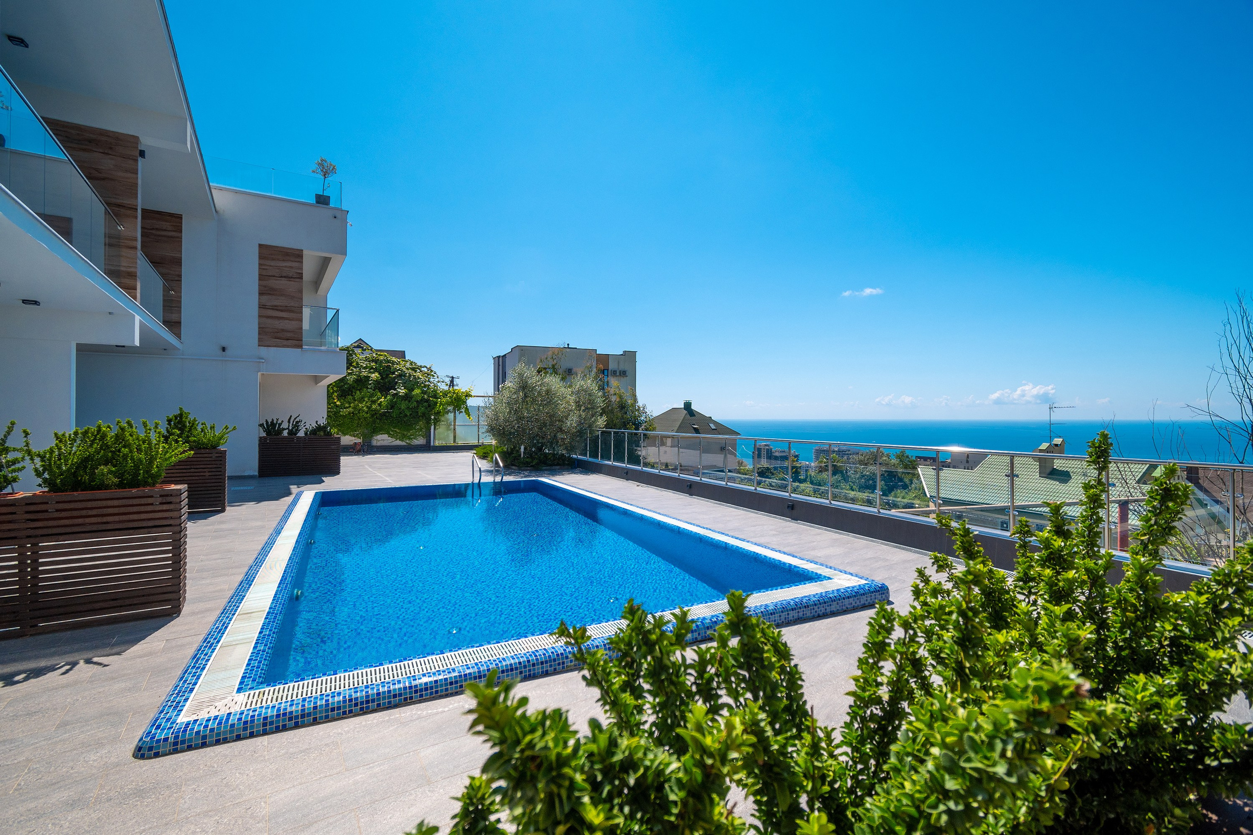 Интерьерная фотосъемка загородного дома с бассейном. Город Сочи. Фасад в современном стиле. Сад и зелень. Ракурс со стороны бассейна. Вид сверху