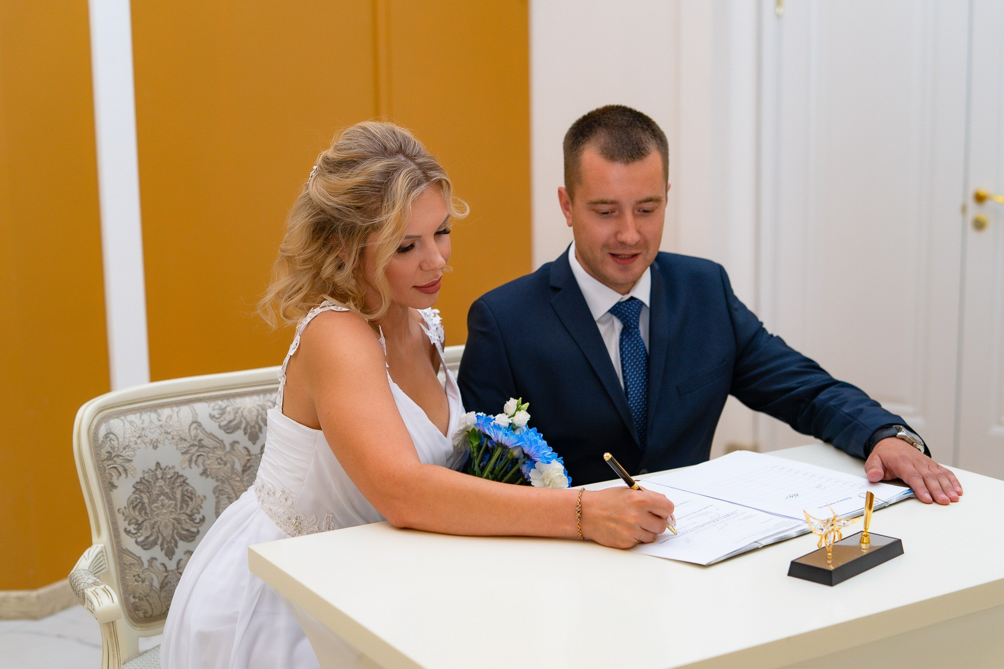жених и невеста ставят подписи в загсе фрунзенского района
