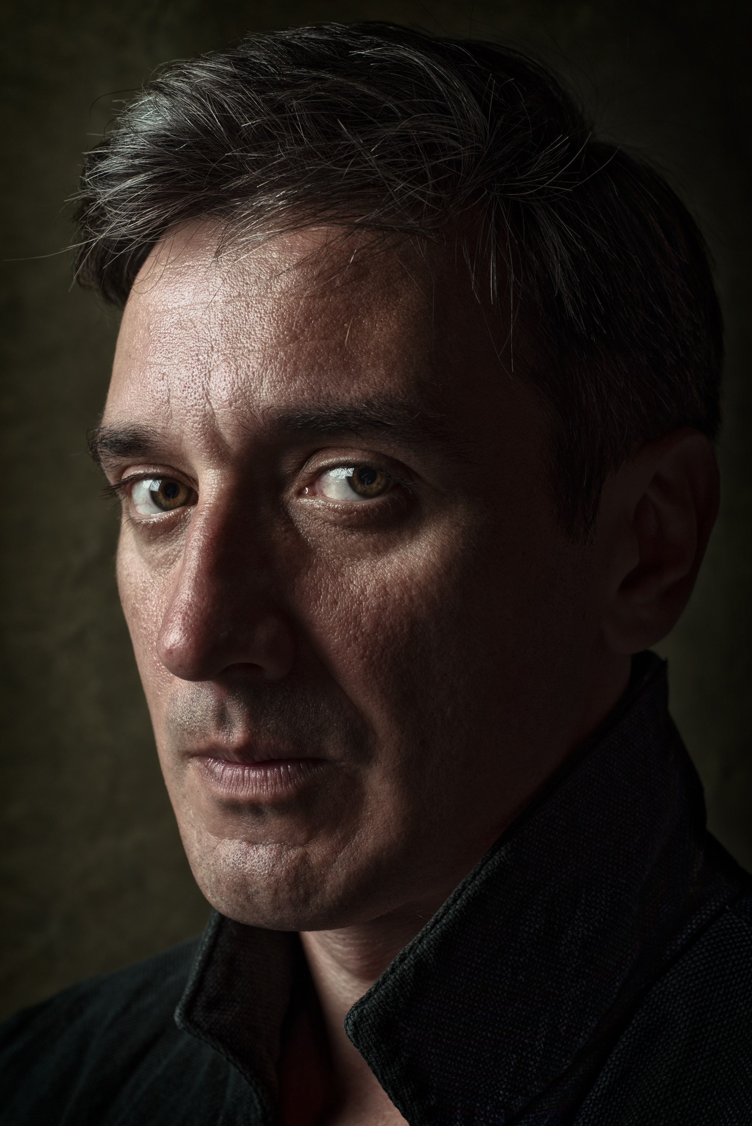 Крупный мужской портрет в пальто в  низком ключе 