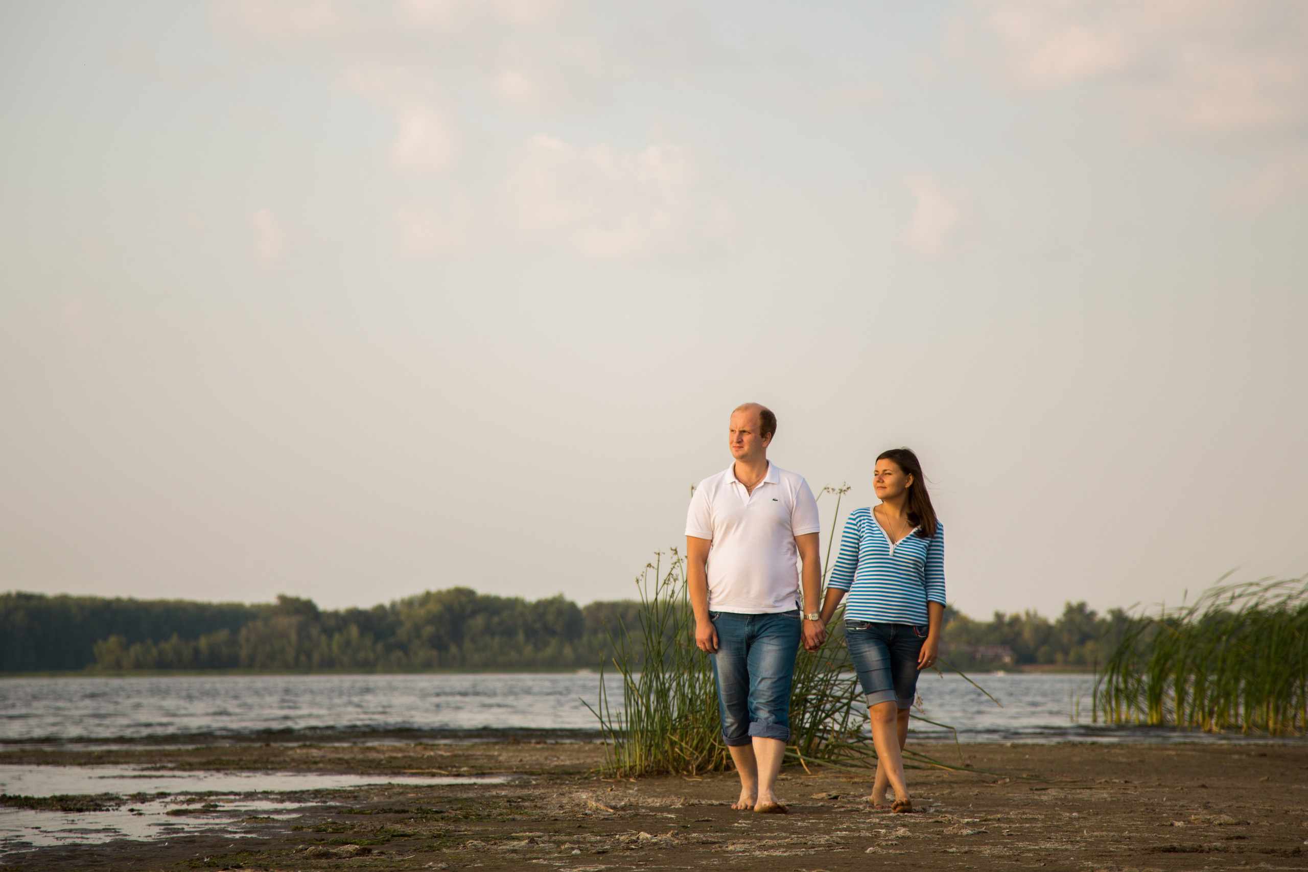 парень и девушка идут по острову, взявшись за руки и смотрят вдаль