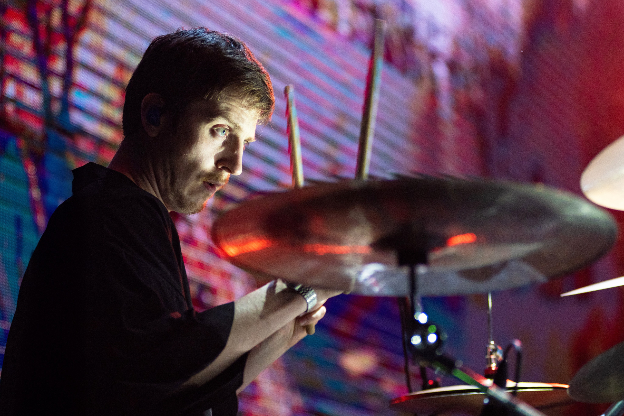 Барабанщик группы «Лампабикт» крупным планом на фоне светодиодного экрана