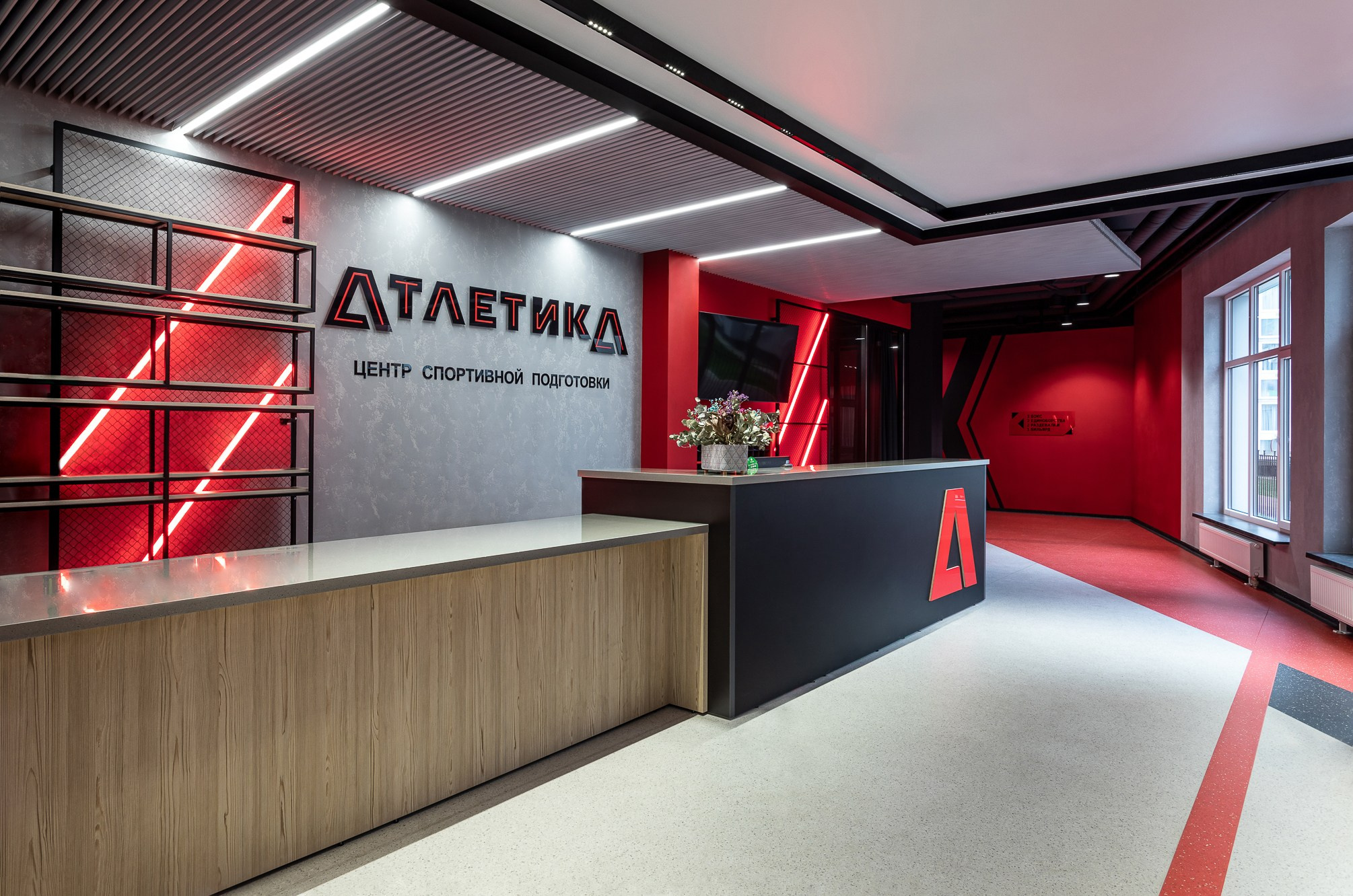 Надпись спортивного клуба Атлетика на стене с красной подсветкой.