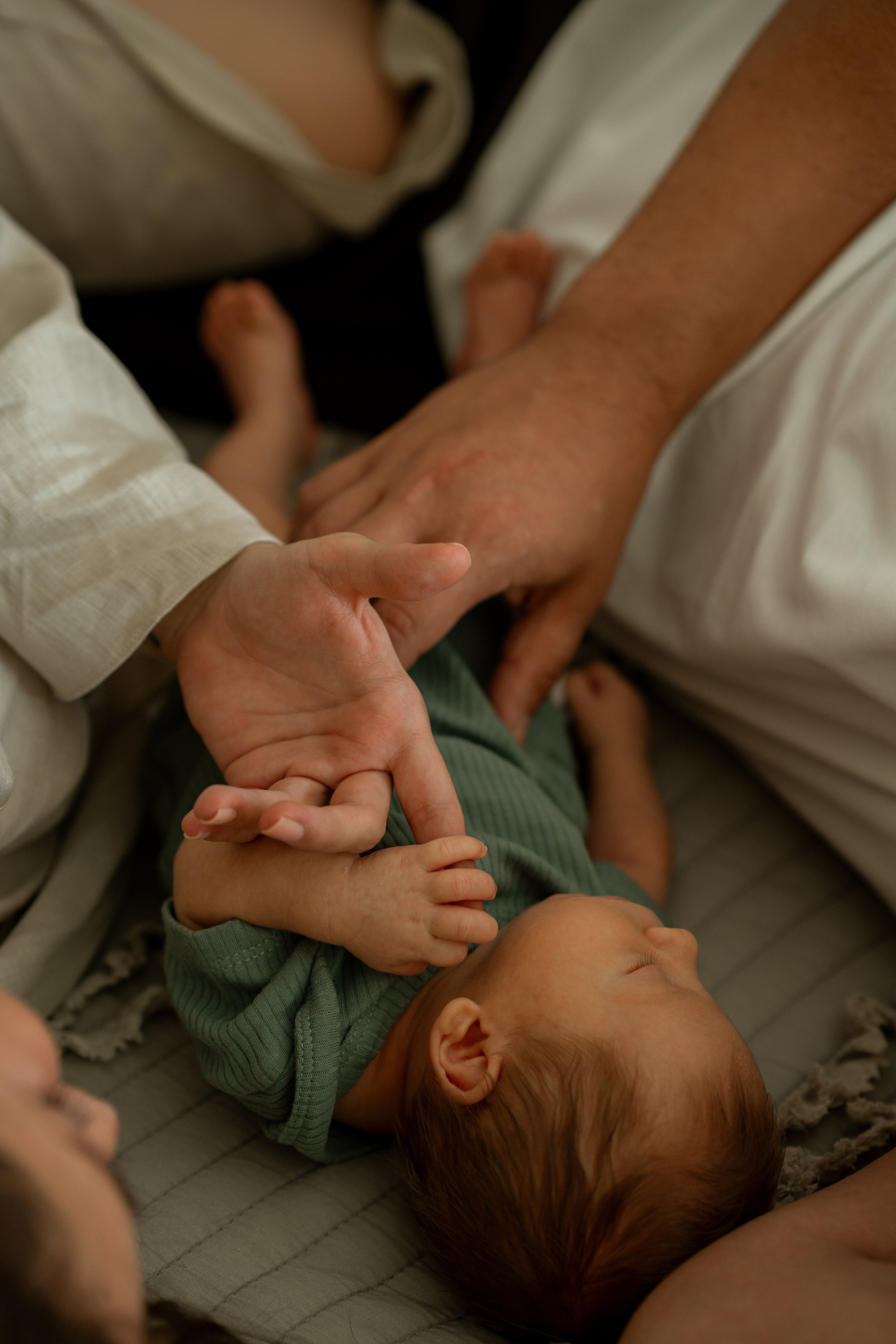 Родитель держит маленькую ручку новорождённого