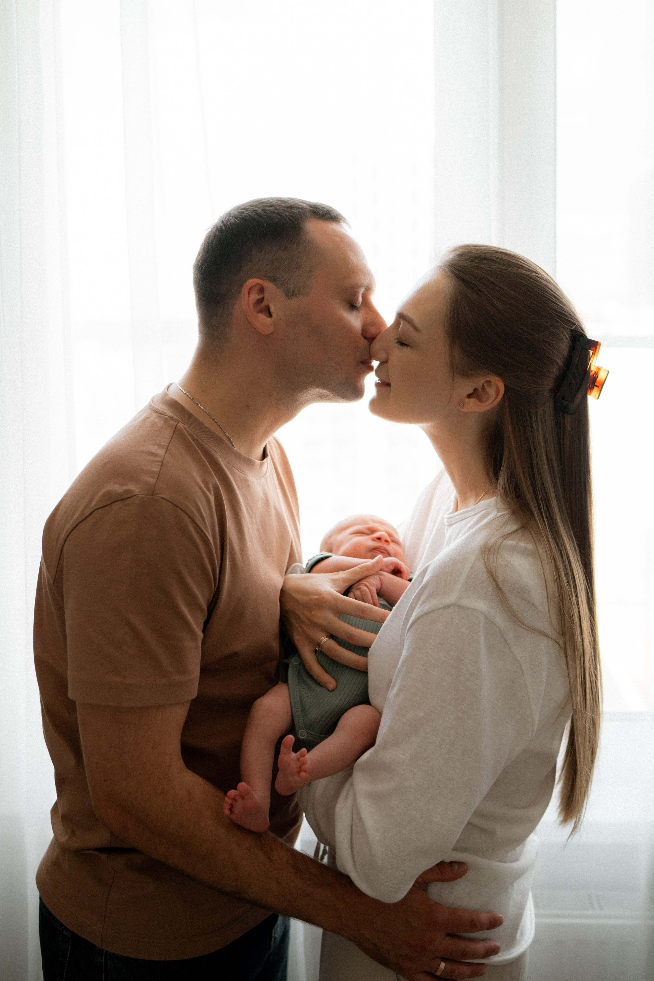 Родители с новорождённым Артёмом у окна