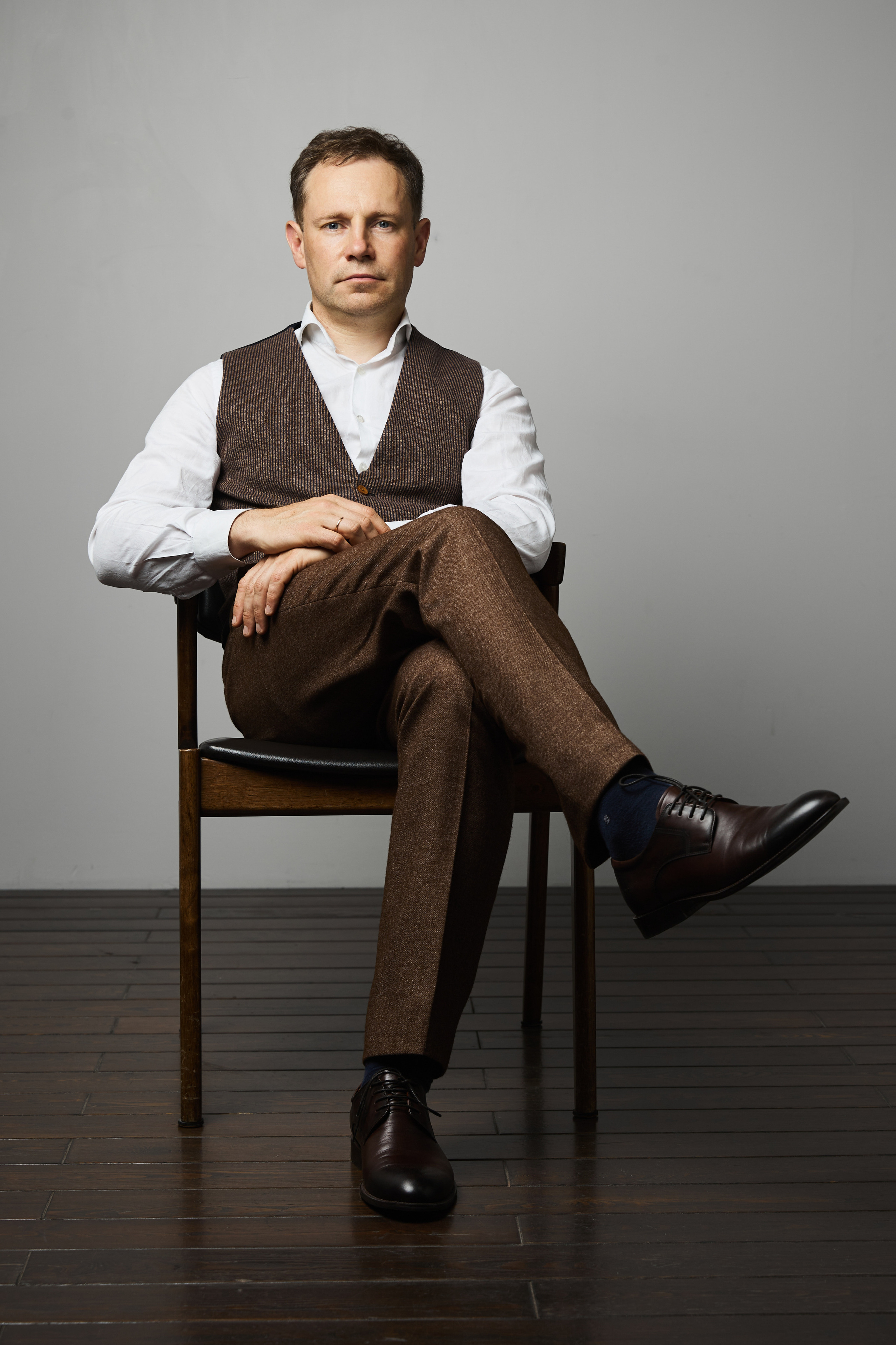 Портрет руководителя на стуле в студии.