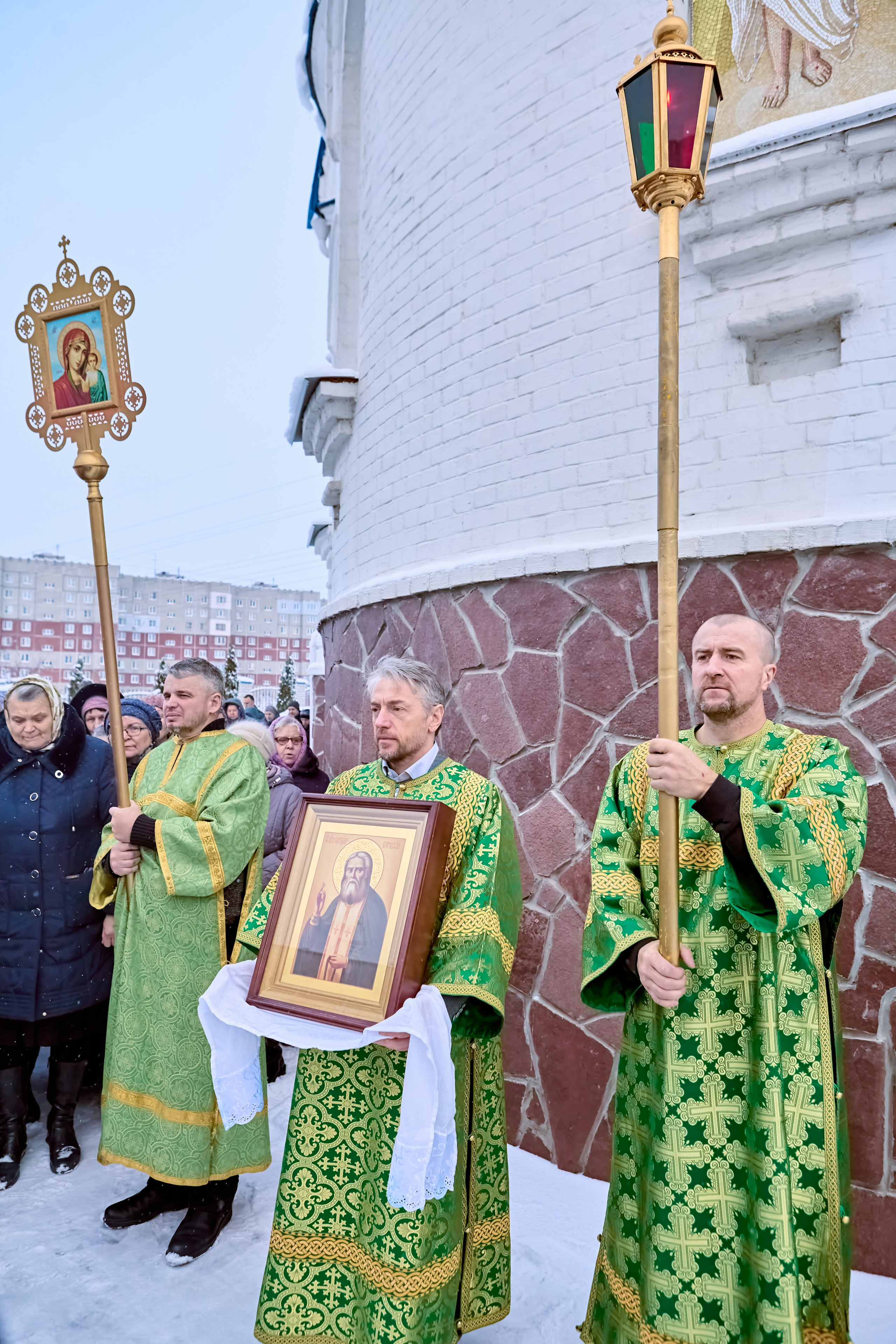 Мужчина с иконой Преподобного Серафима Саровского и алтарники с фонарем и иконой