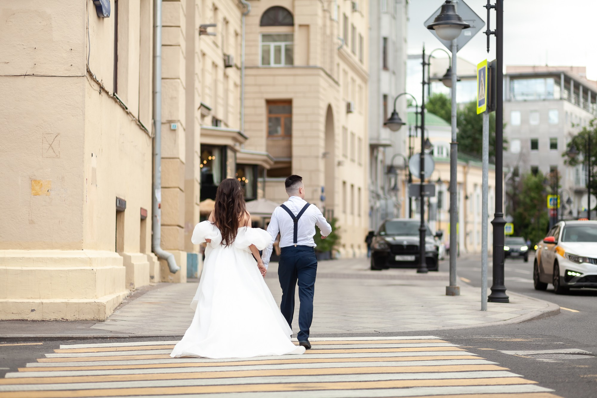 Молодожены уходят вдаль по улице