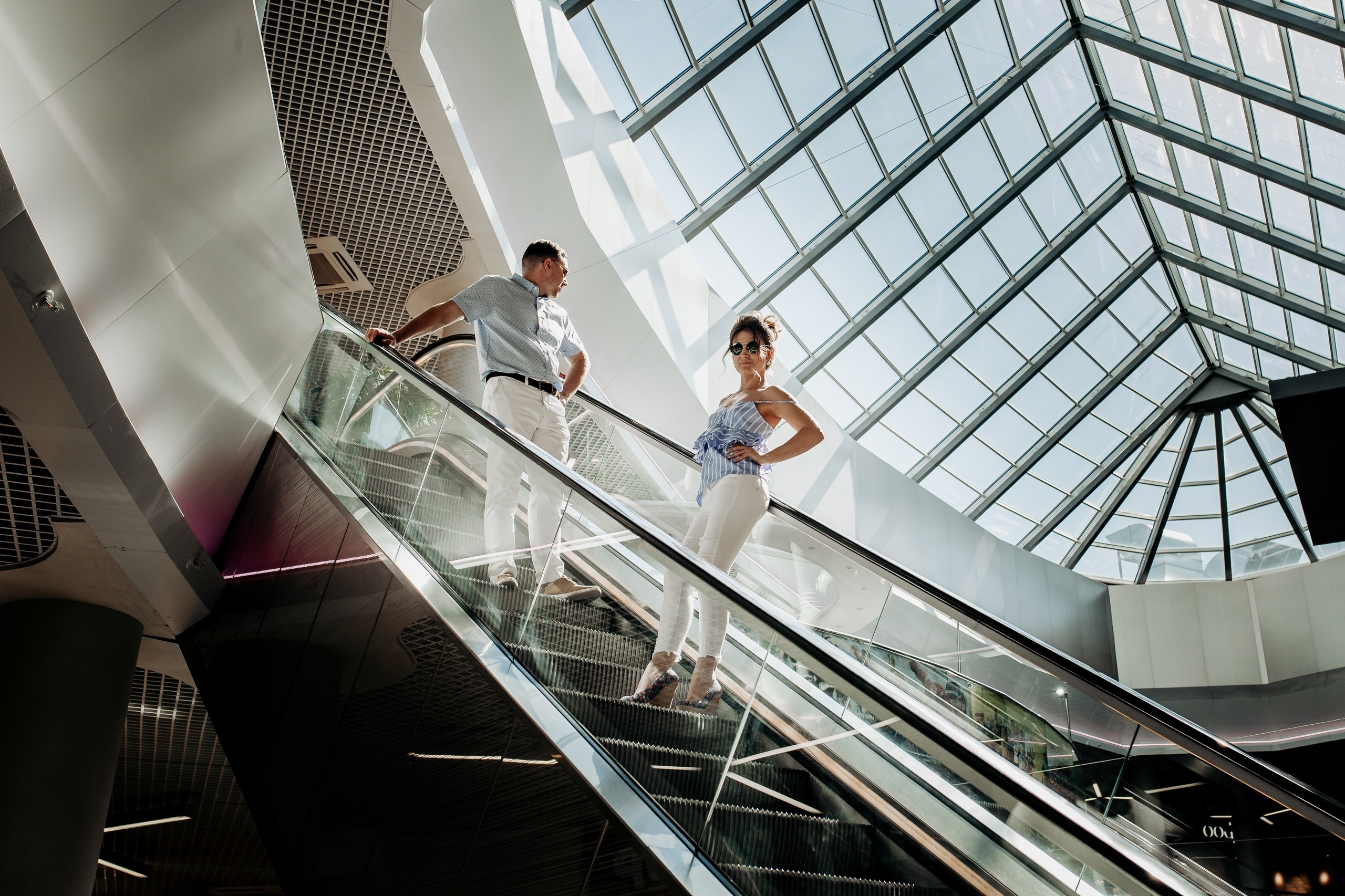 Парень и девушка едут на эскалаторе в торговом центре Смоленска 