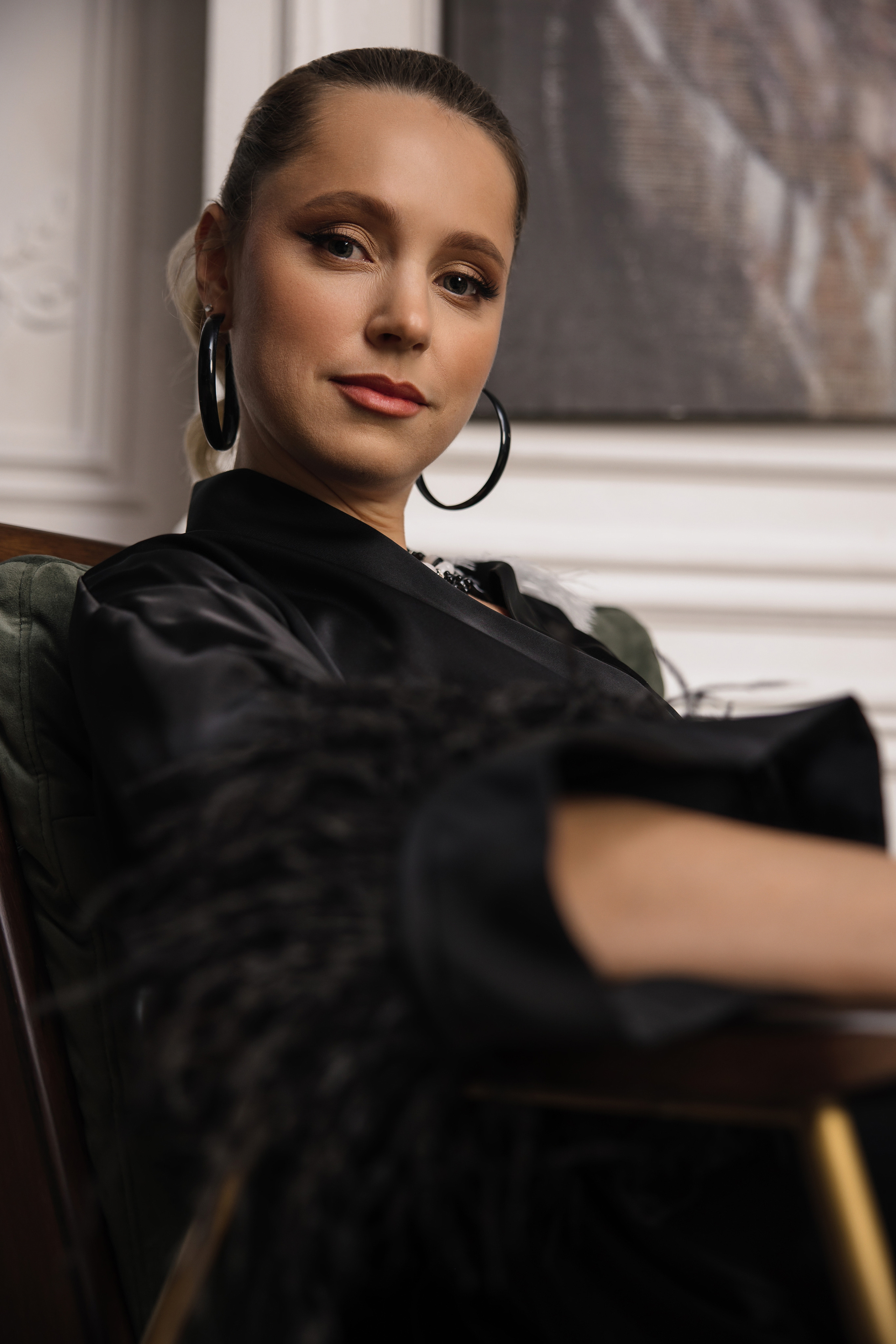 Фотография эксперта знающего себе цену, в блузке с черными перьями на рукавах.