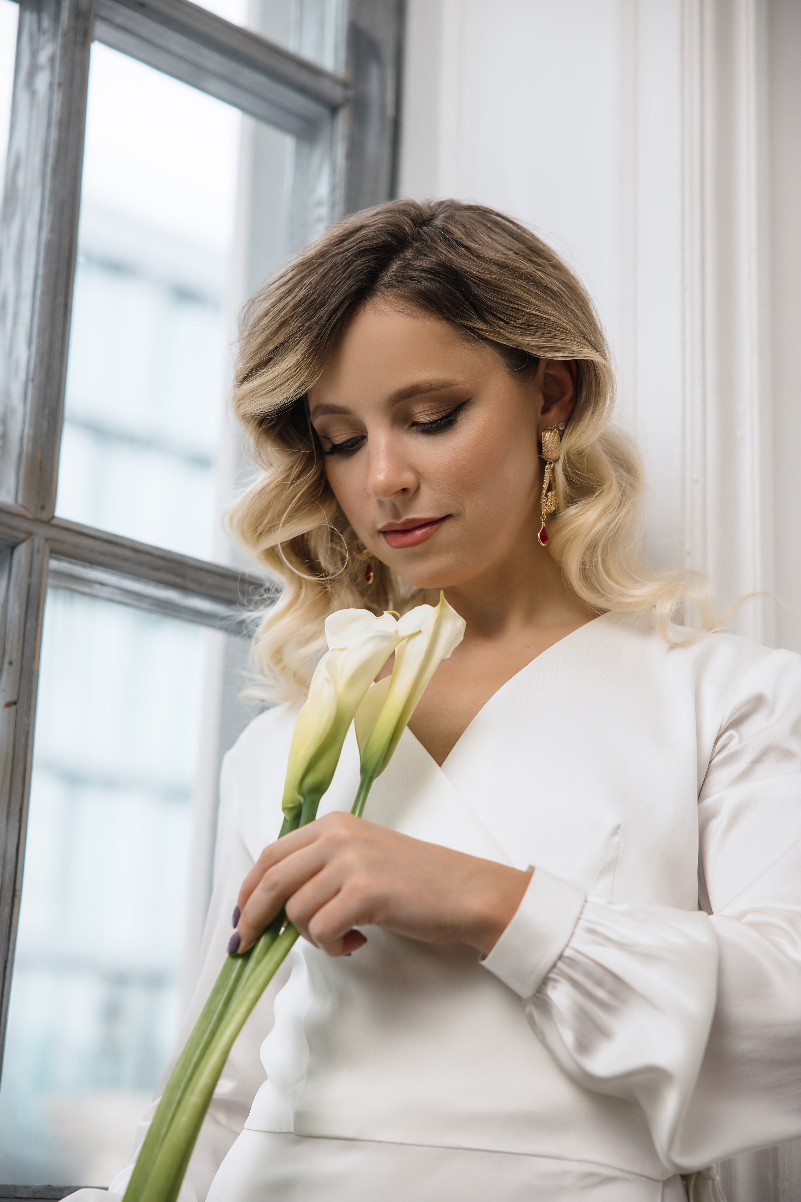 Портрет блондинки держащую в руках красивый букет цветов.