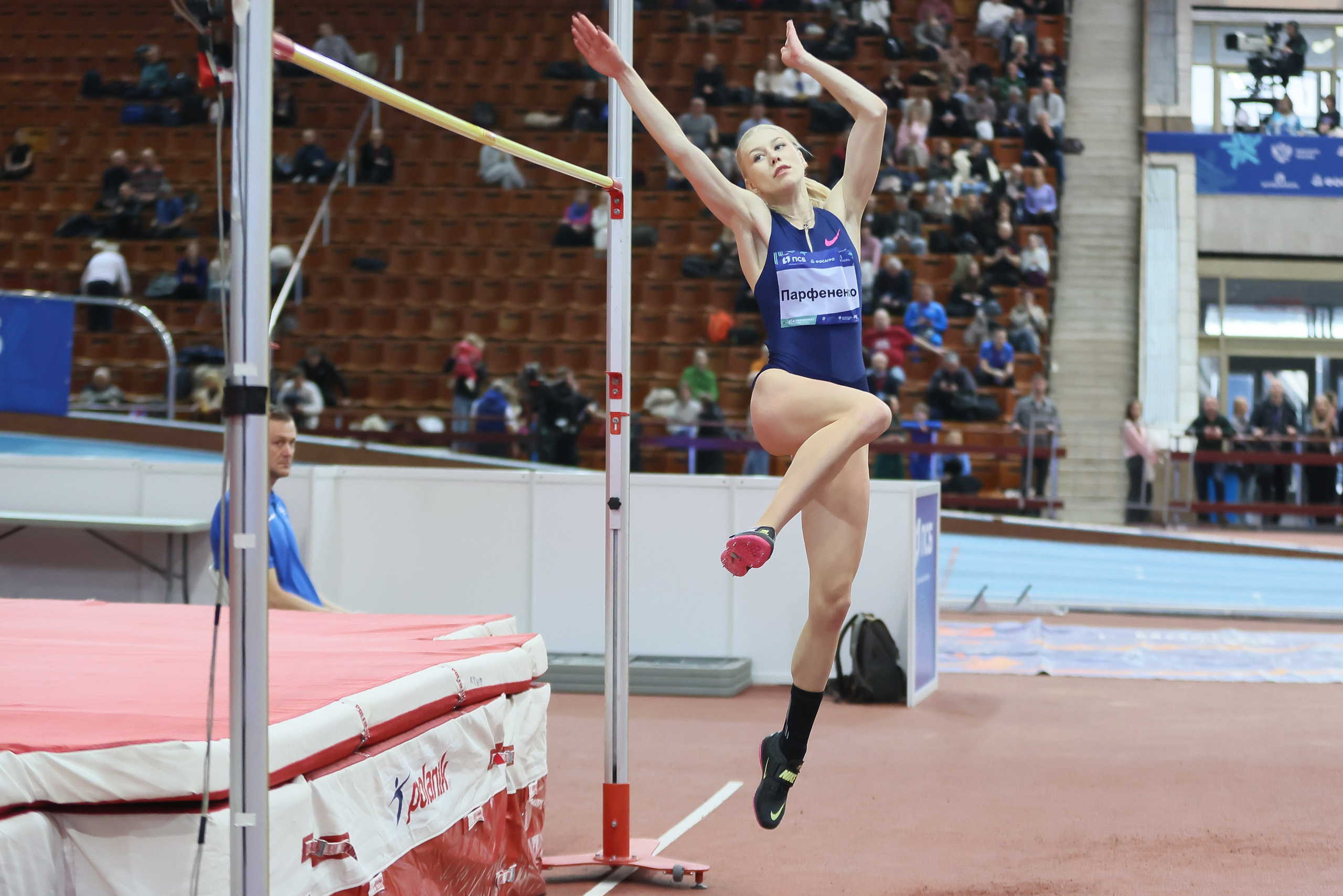 Прыгунья в высоту преодолевает планку  