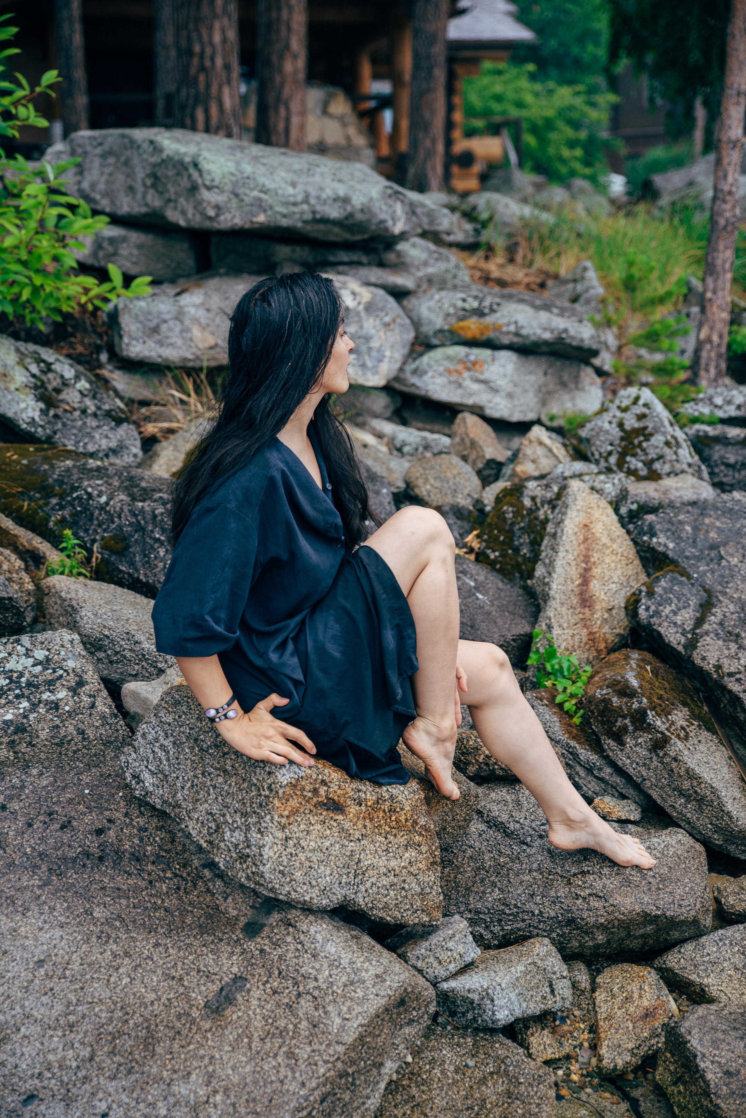 девушка на камнях у озера в лесу