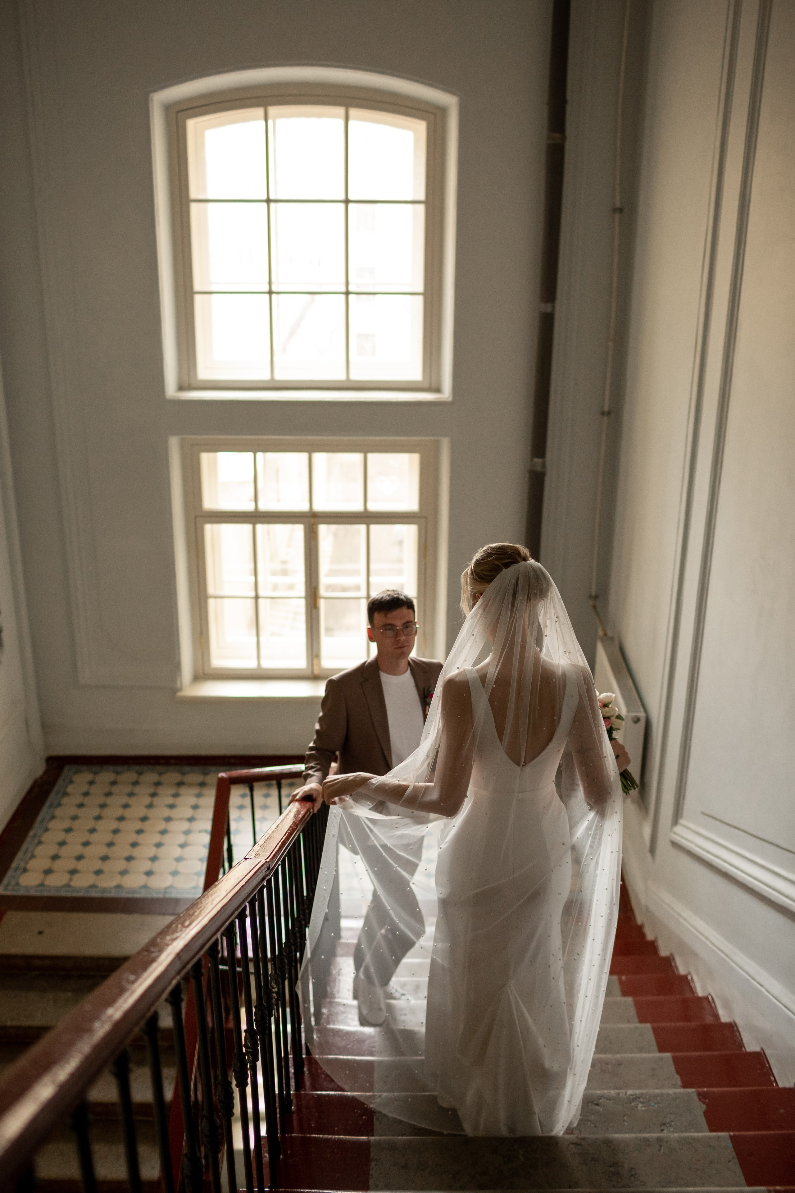 Невеста спускается к жениху в эстетичной парадной.