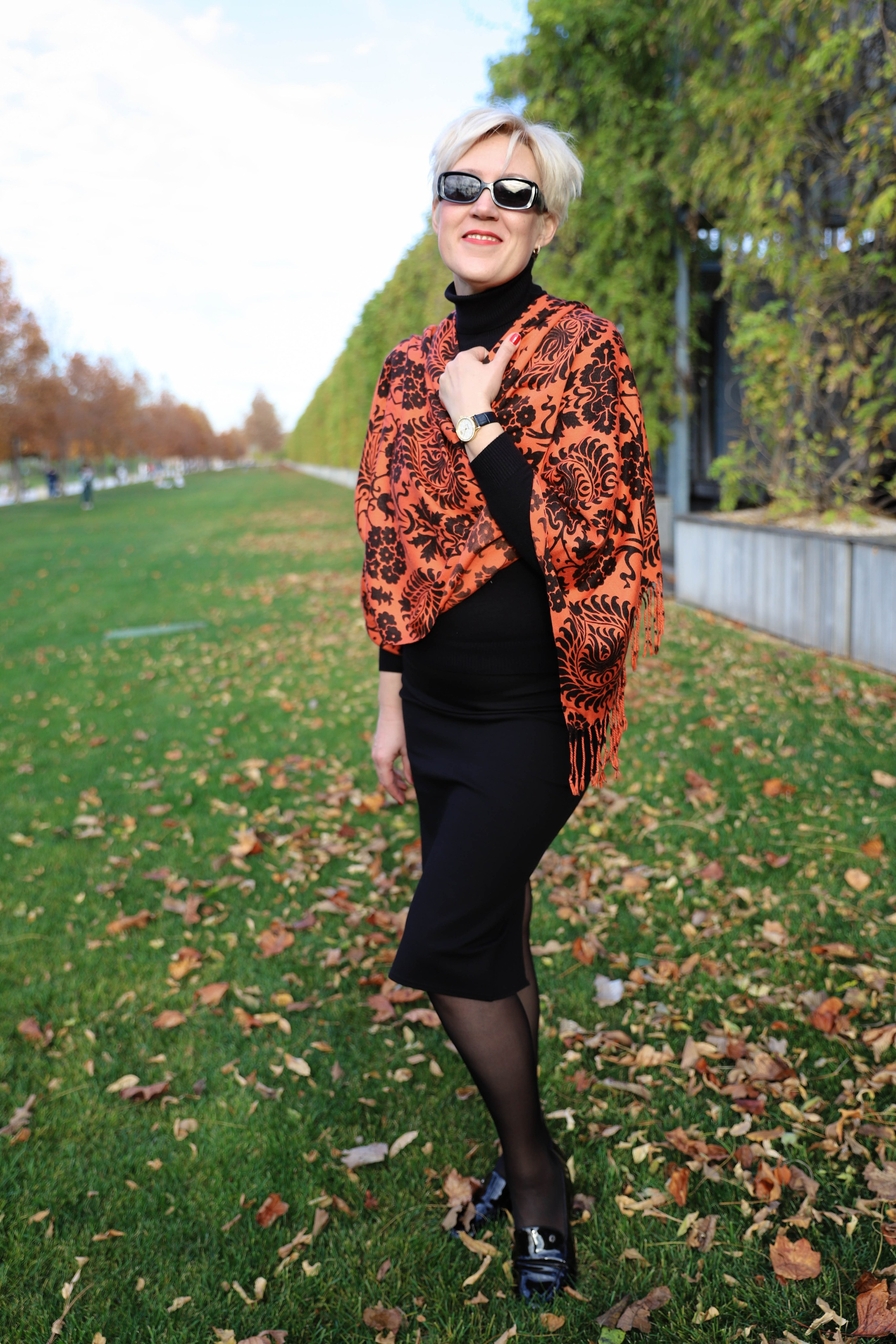 Осеннее тепло: девушка с короткими волосами в стильном оранжевом платке улыбается на фоне аллей парка Галицкого