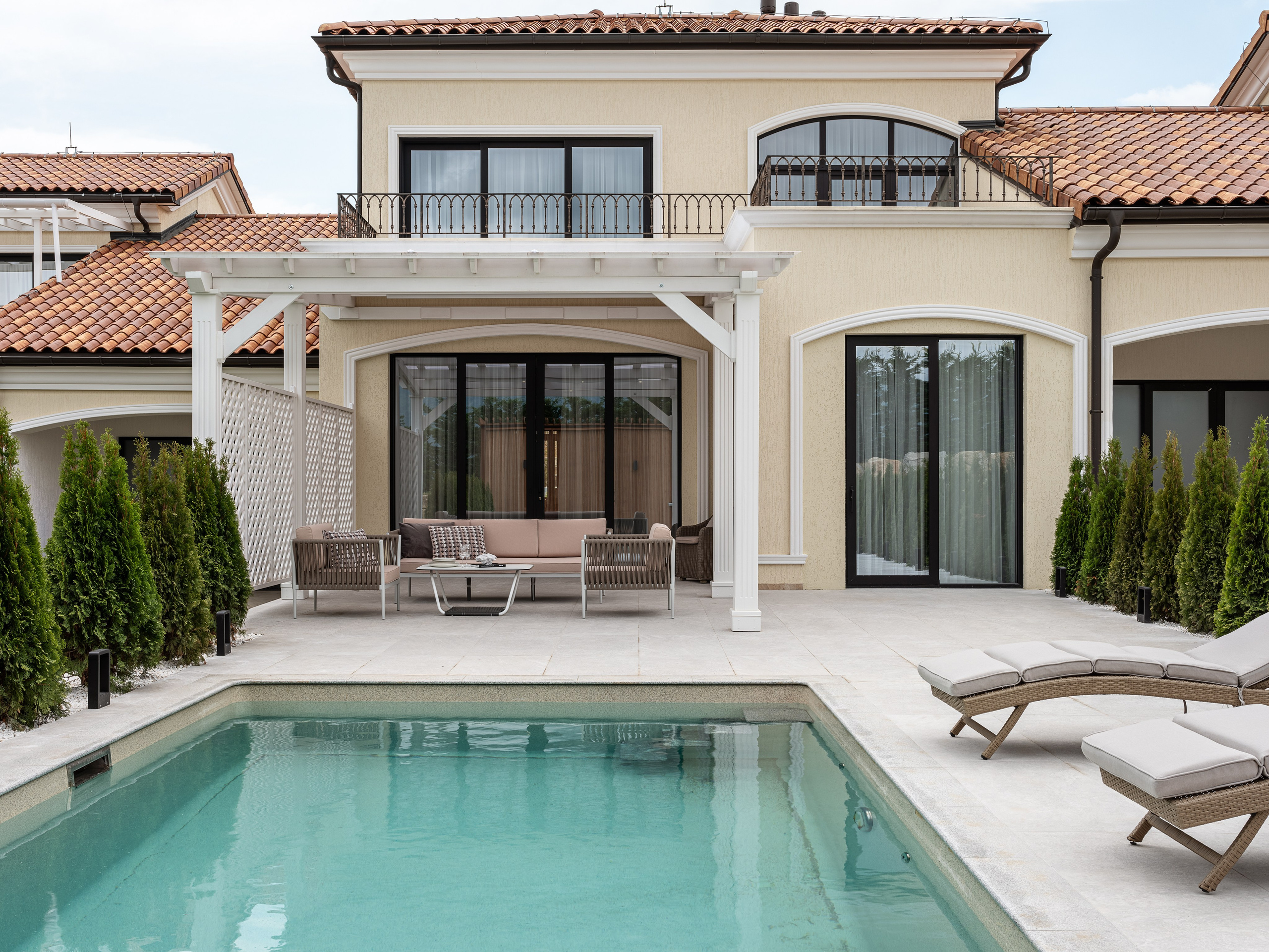Современный загородный дом в средиземноморском стиле с бассейном, террасой и лаунж-зоной под перголой, гармоничный экстерьер с декоративными арками, проект дизайнер Василисса Бачева, стилист Наталья Якушева, фотограф Сергей Денисенко.