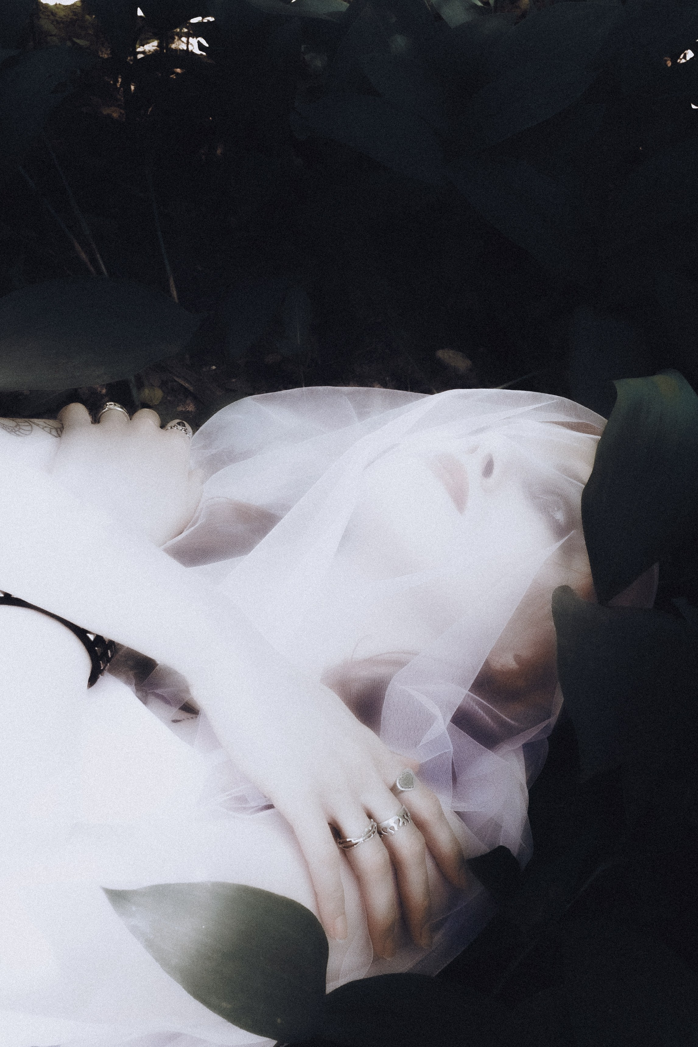 Фотограф Александра Овечкина Пенза: невеста лежит среди зелени, лицо полностью скрыто вуалью, мистический образ.