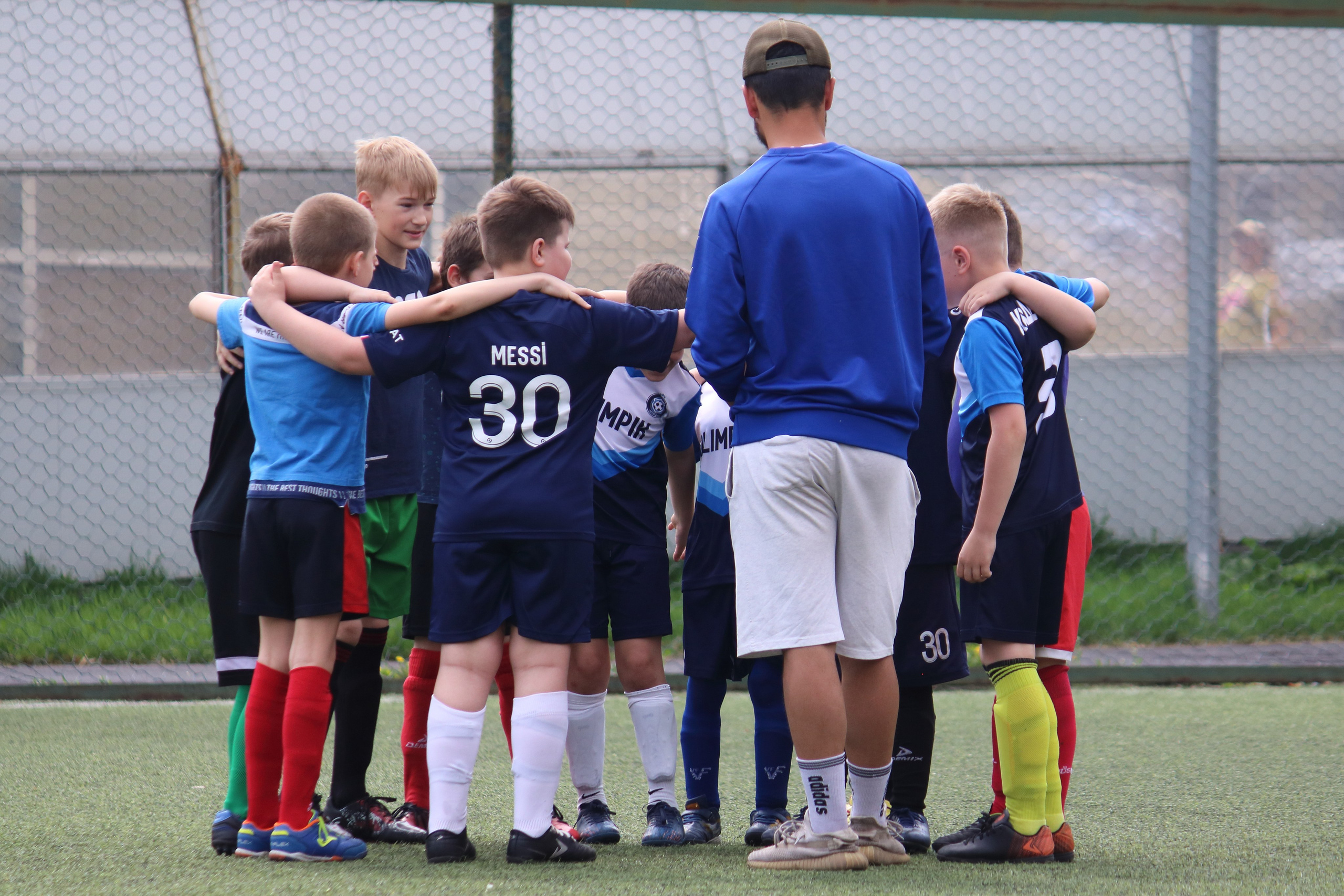 Тренер смотрит на сплоченность детской футбольной команды