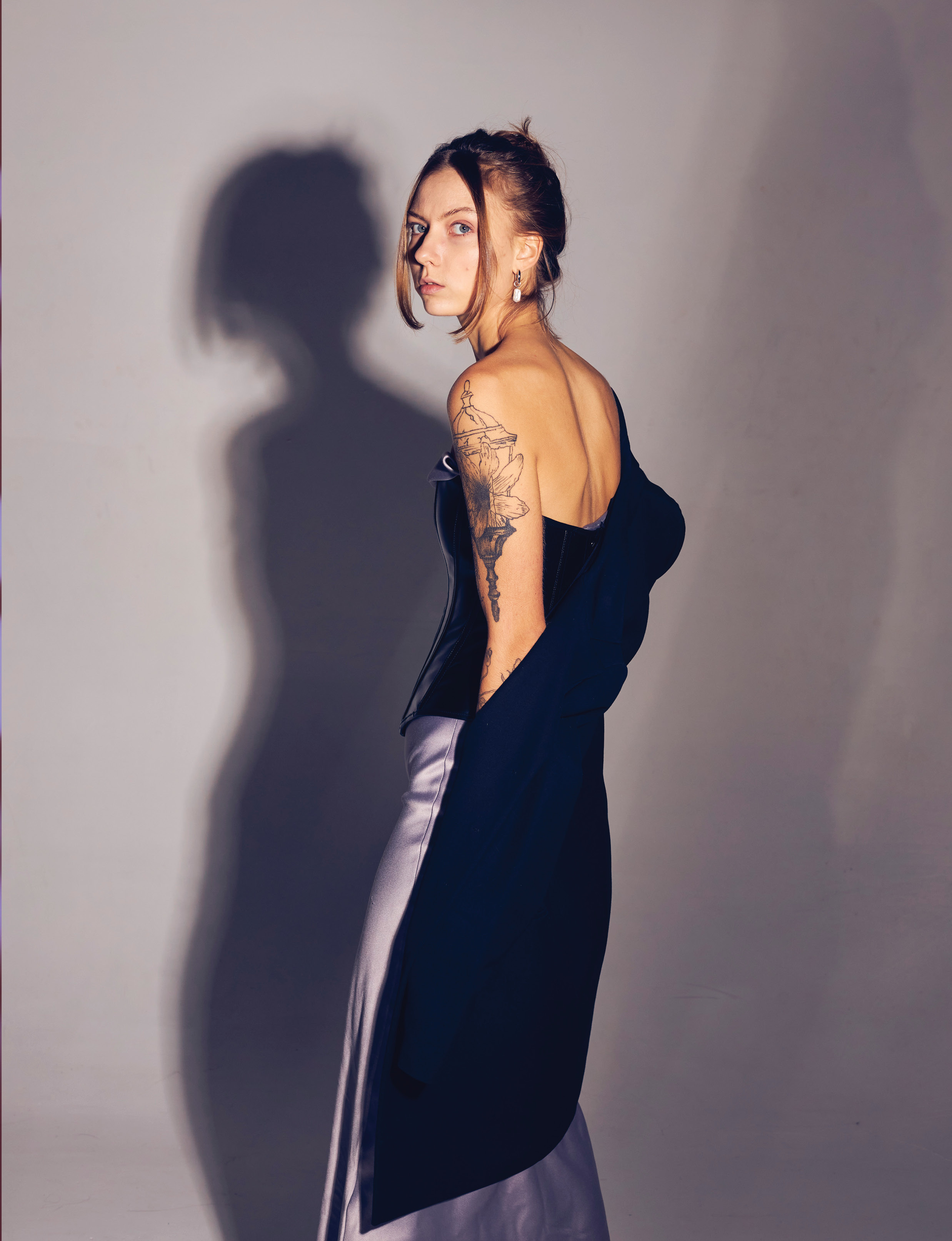 Портрет девушки со спины, она чуть выгнула спину и смотрит вдаль