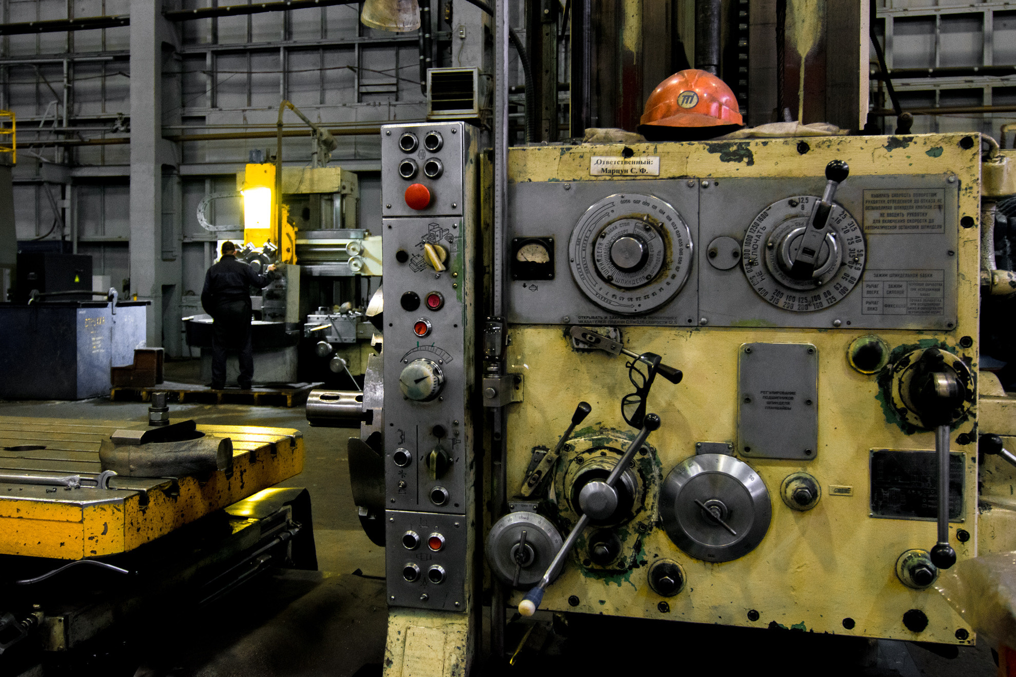 Производство, станок в желтых тонах с каской