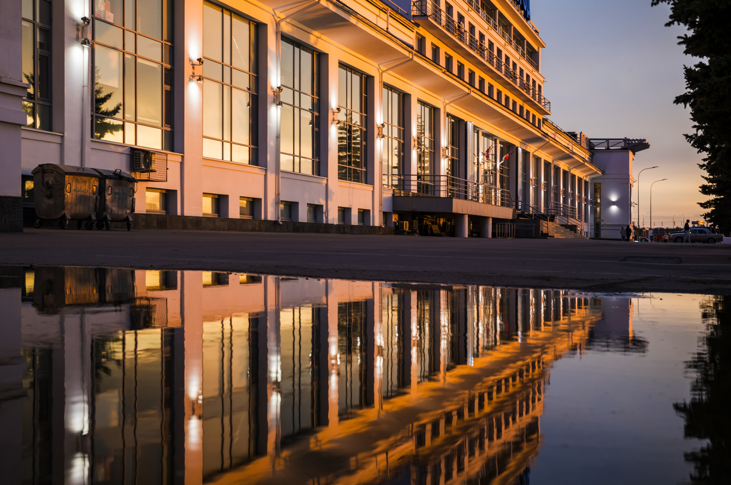 Вид на здание речного вокзала с отражением в луже в Нижнем Новгороде