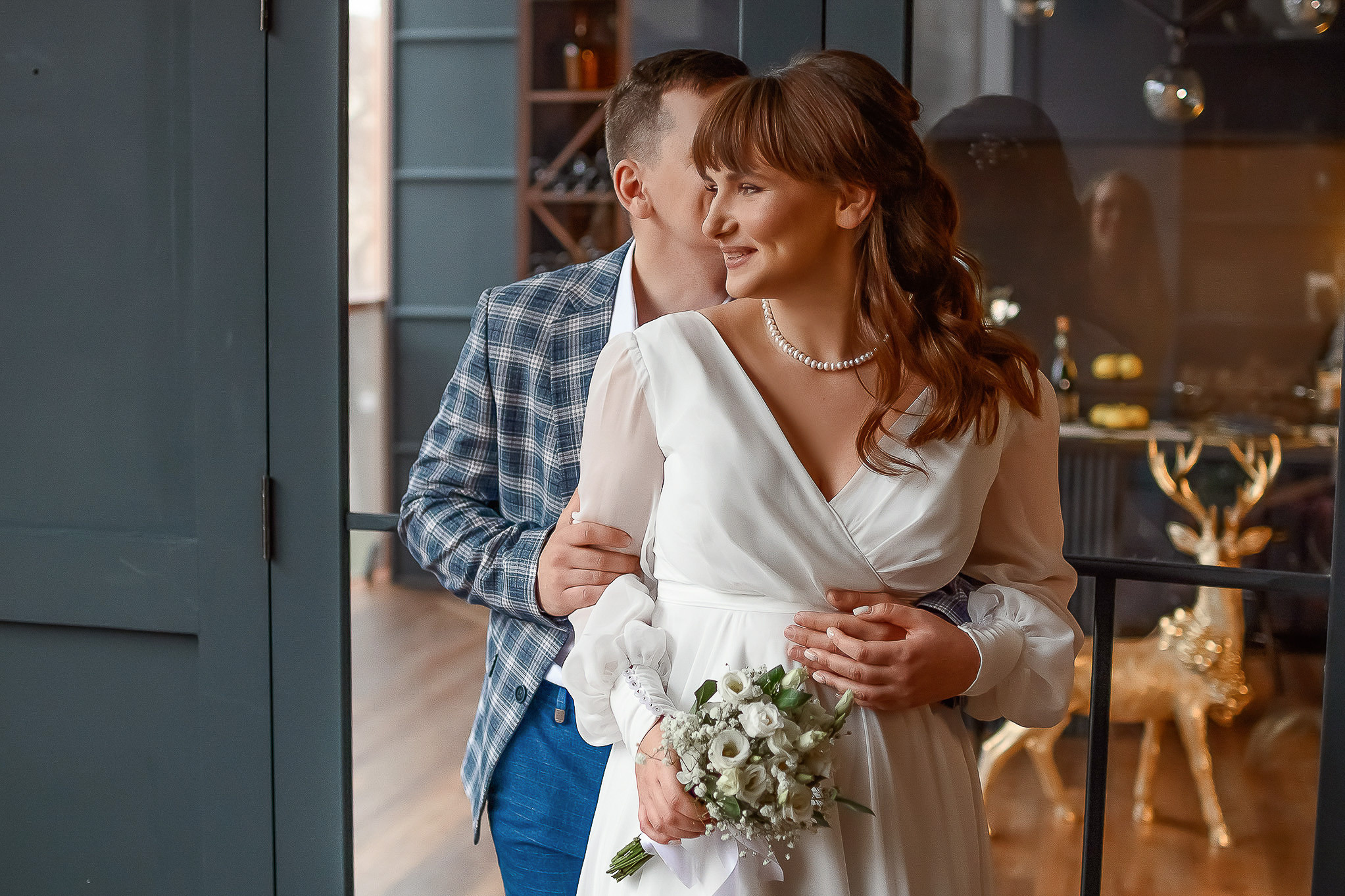 Молодожены с букетом белых цветов на свадебной фотосессии.