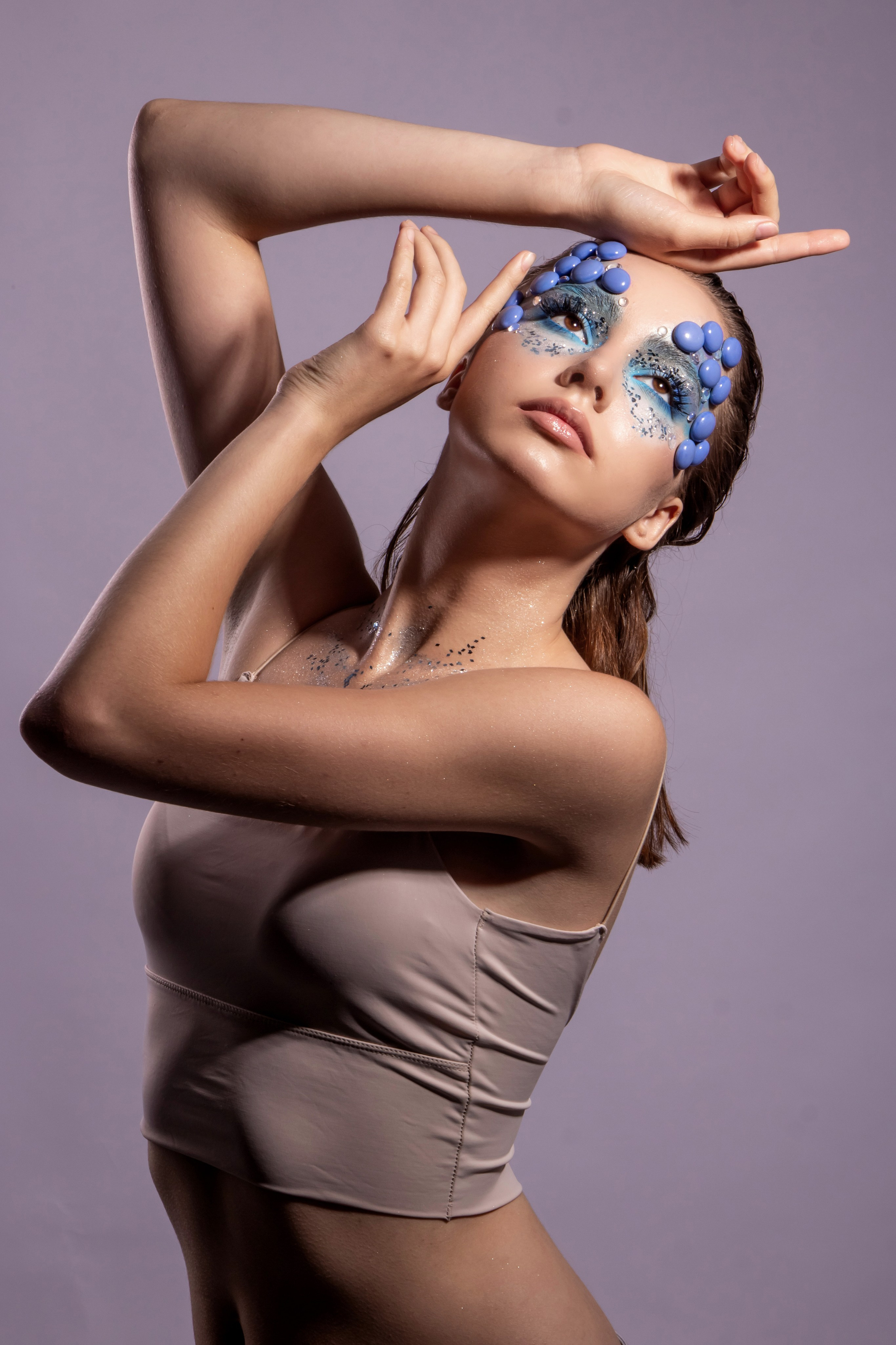 " standing  young lady in position hand on head and  the other on the face photo with make up in studio ".