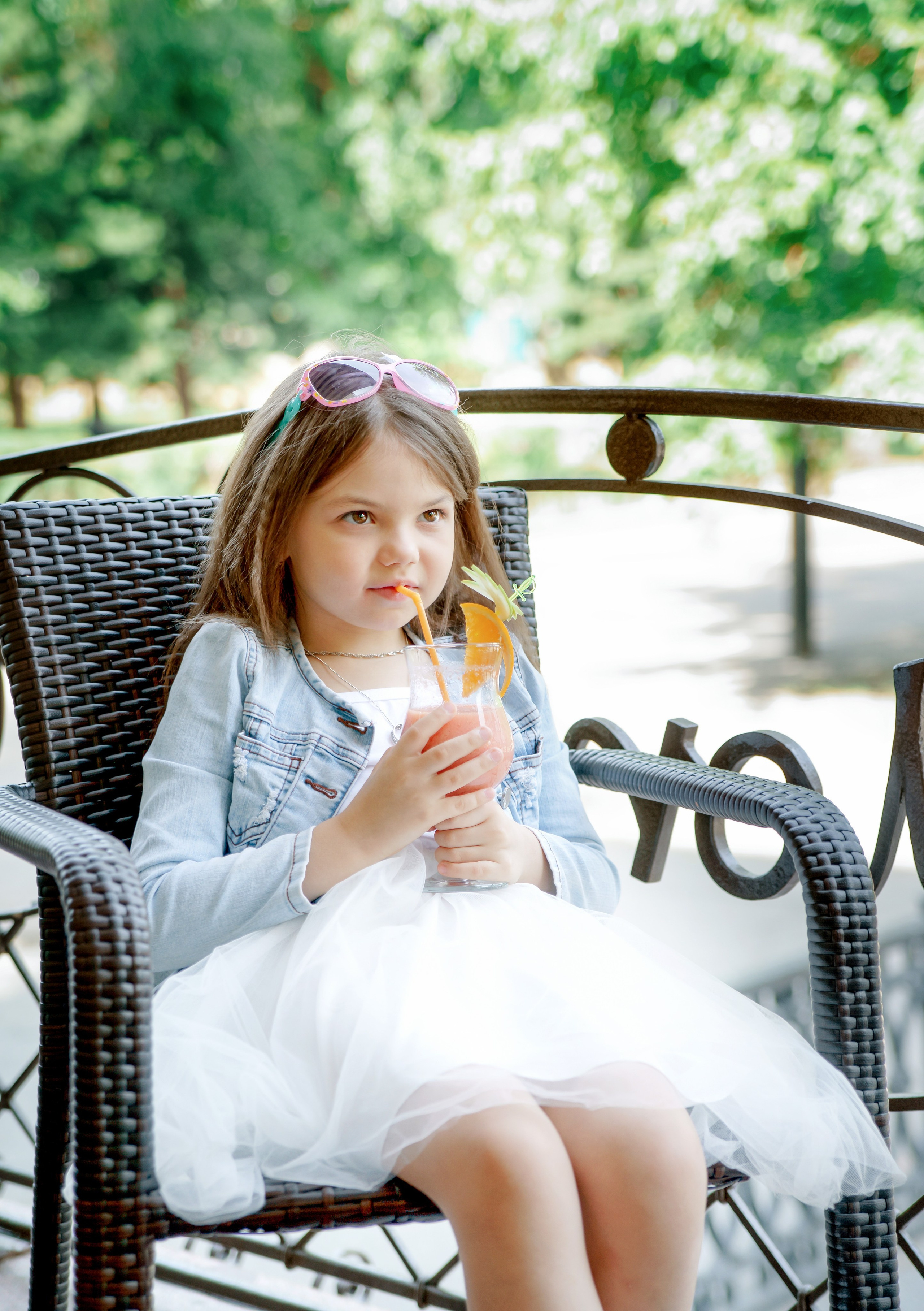 Детская фотосессия летом - девочка сидя с коктейлем