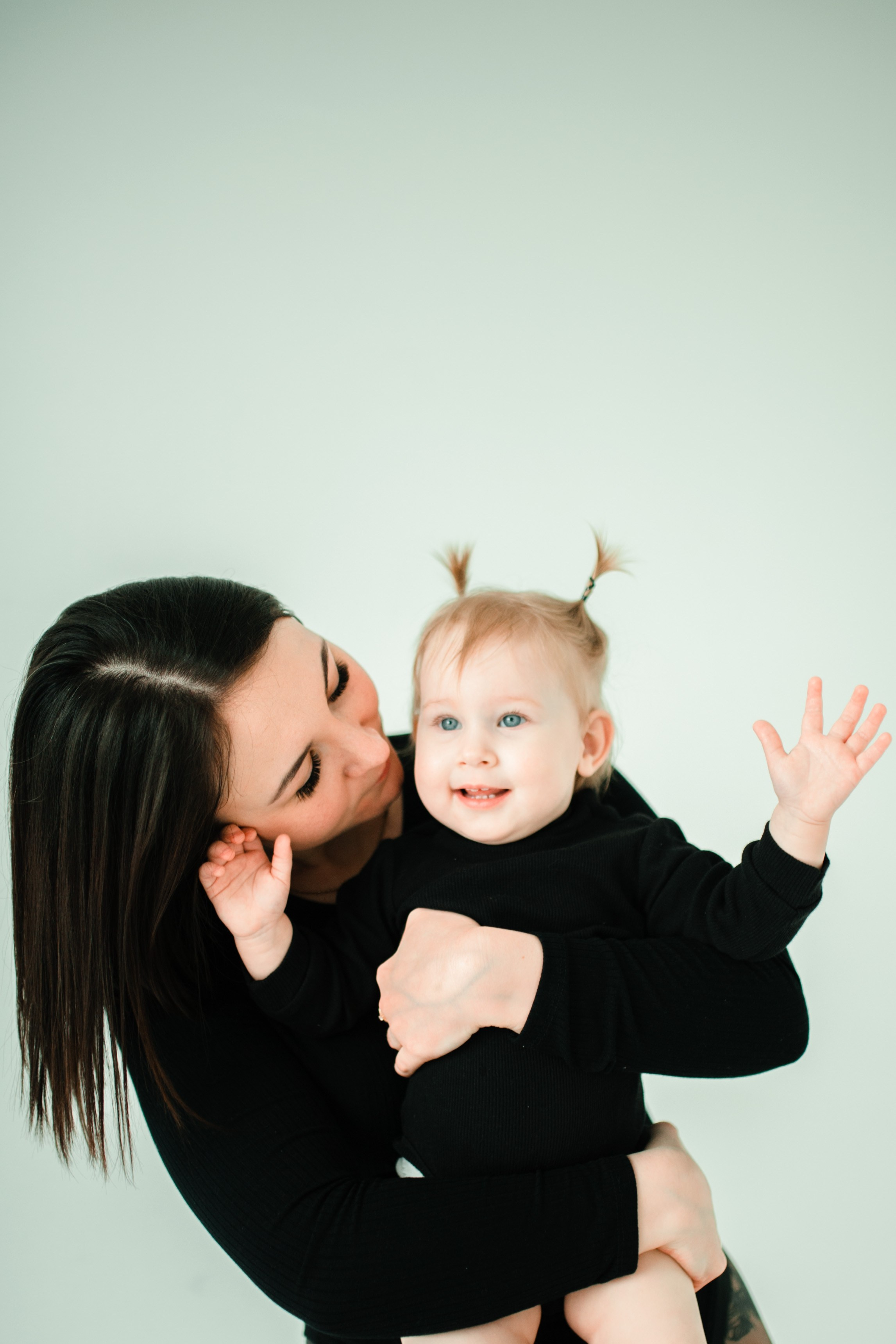 Семейная фотосессия в студии родители и дети на фоне светлого фона, улыбаются.