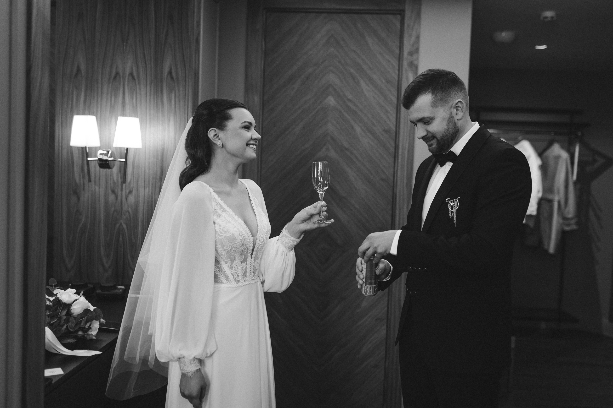 Молодожены празднуют в роскошном номере, декорированном цветами и свечами.