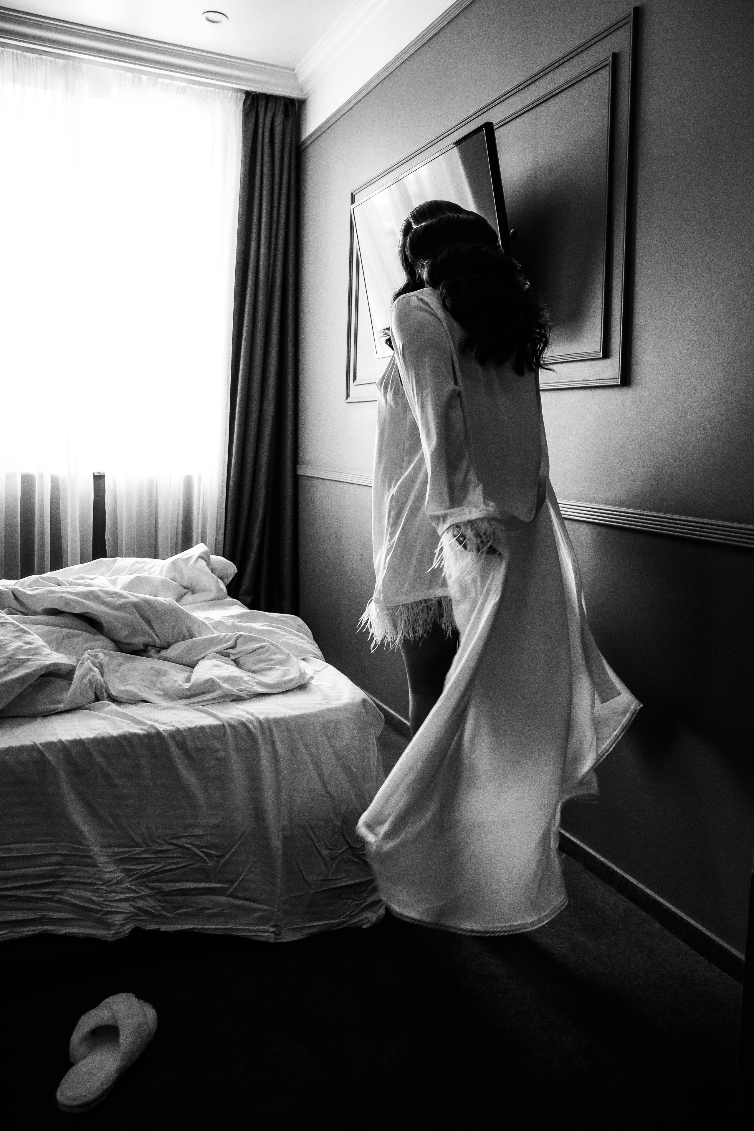 девушка идет к окну в номере