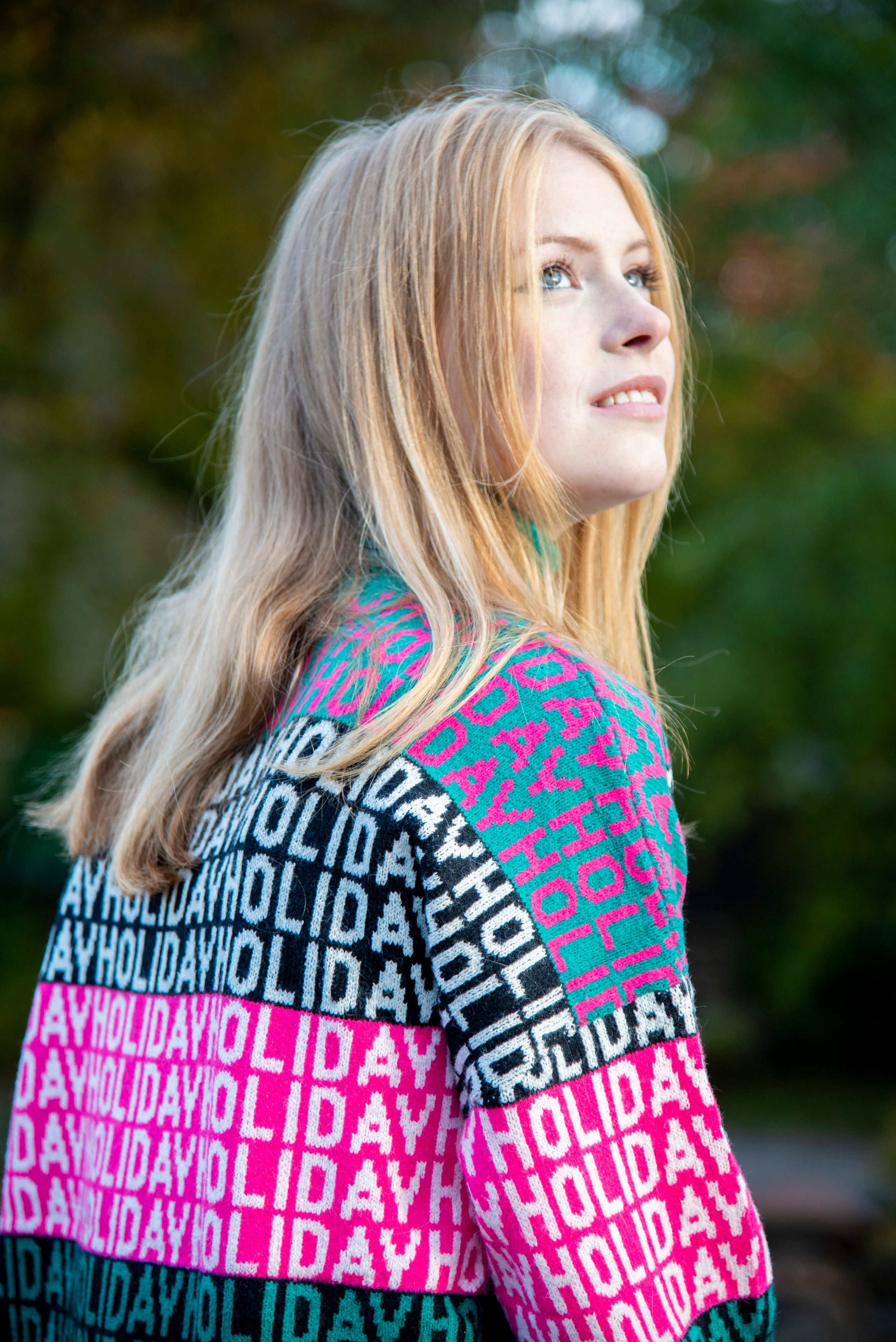 молодая девушка студентка. блондинка. длинные волосы. розово-зелёный свитер. парк Лога . осень