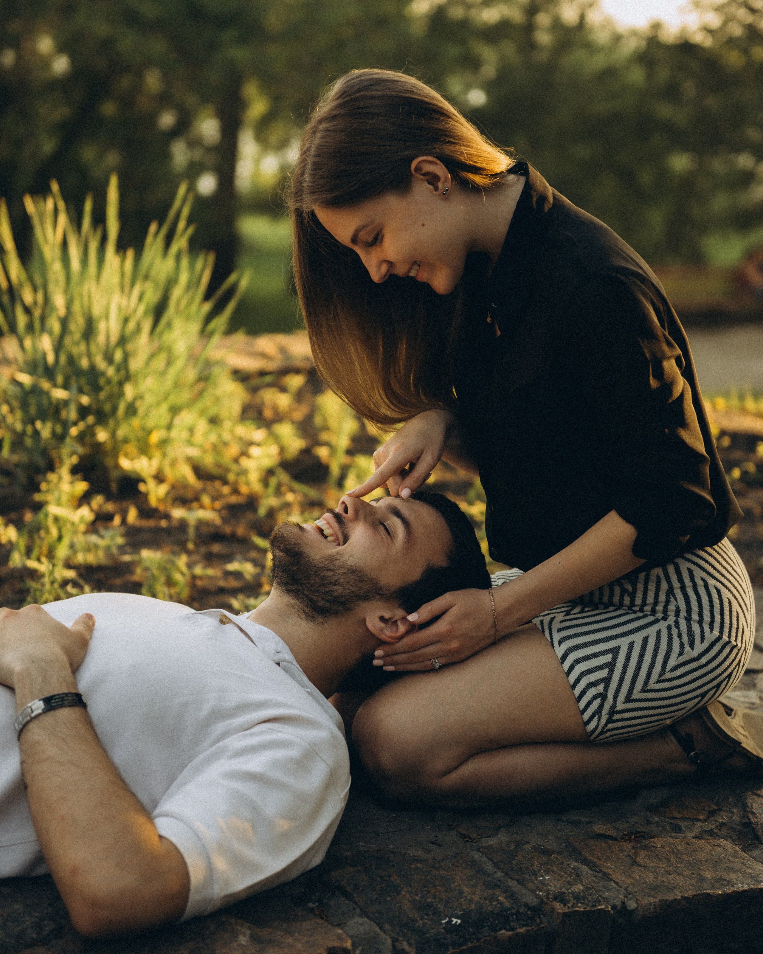 Он лежит на её коленях, игривый момент и смех. Лайфстайл-фотосессия для двоих на траве у Оби, Новосибирск, Василий Дан.