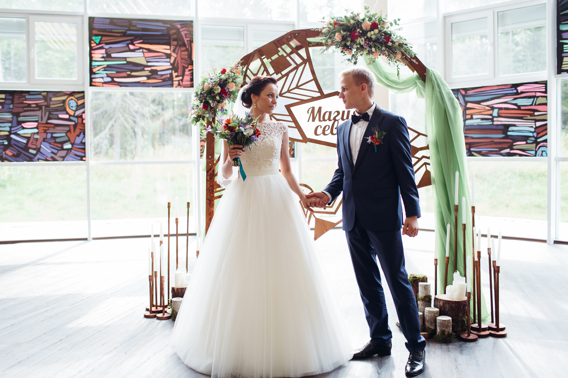 Жених и невеста на фоне арки.