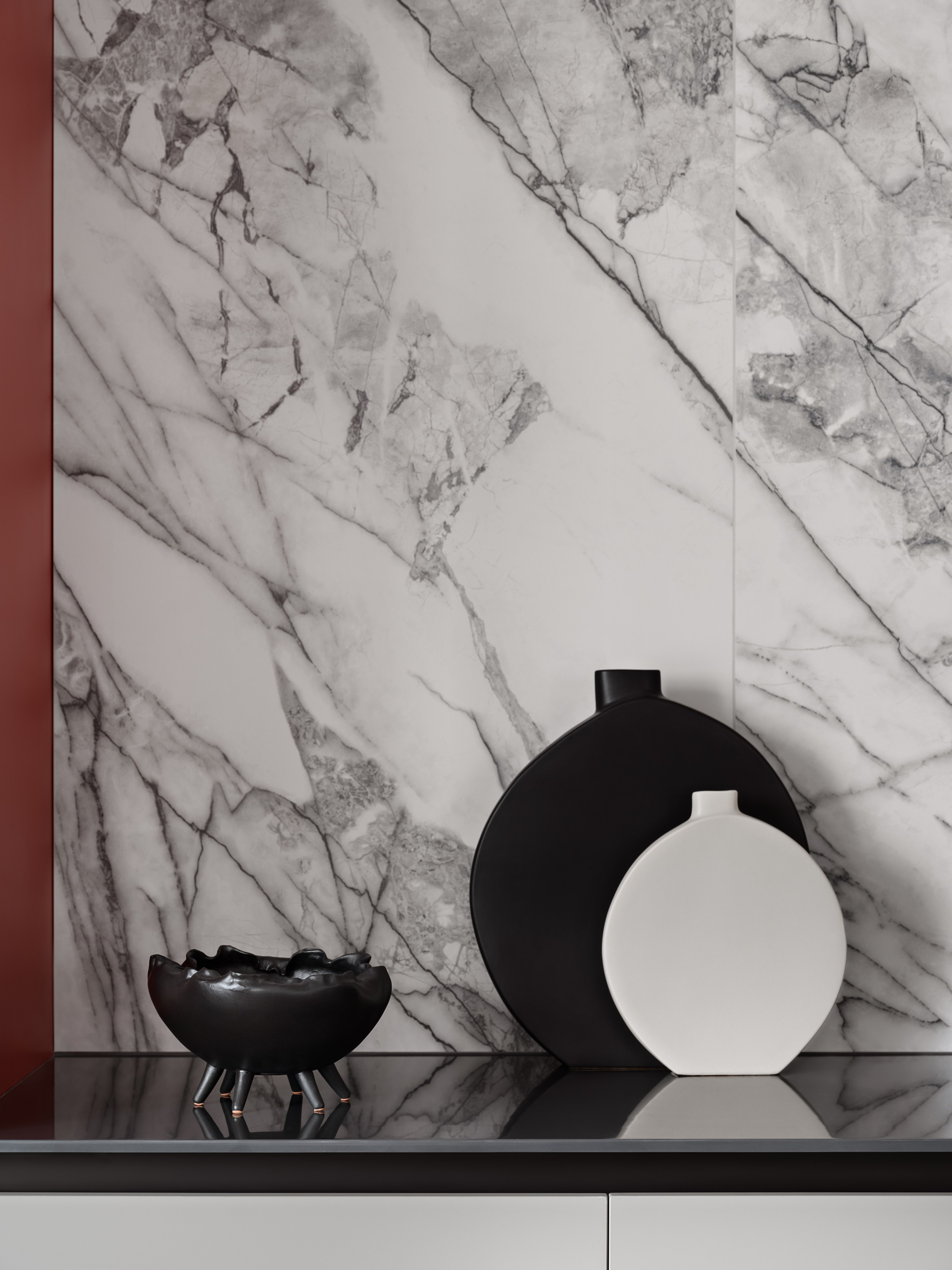 Фрагмент кухни с акцентом на мраморный фартук, стильные черно-белые вазы и керамические аксессуары на рабочей поверхности. Работа дизайнера Антона Логинова, стилиста Алёны Мощенской, фото Сергея Денисенко.