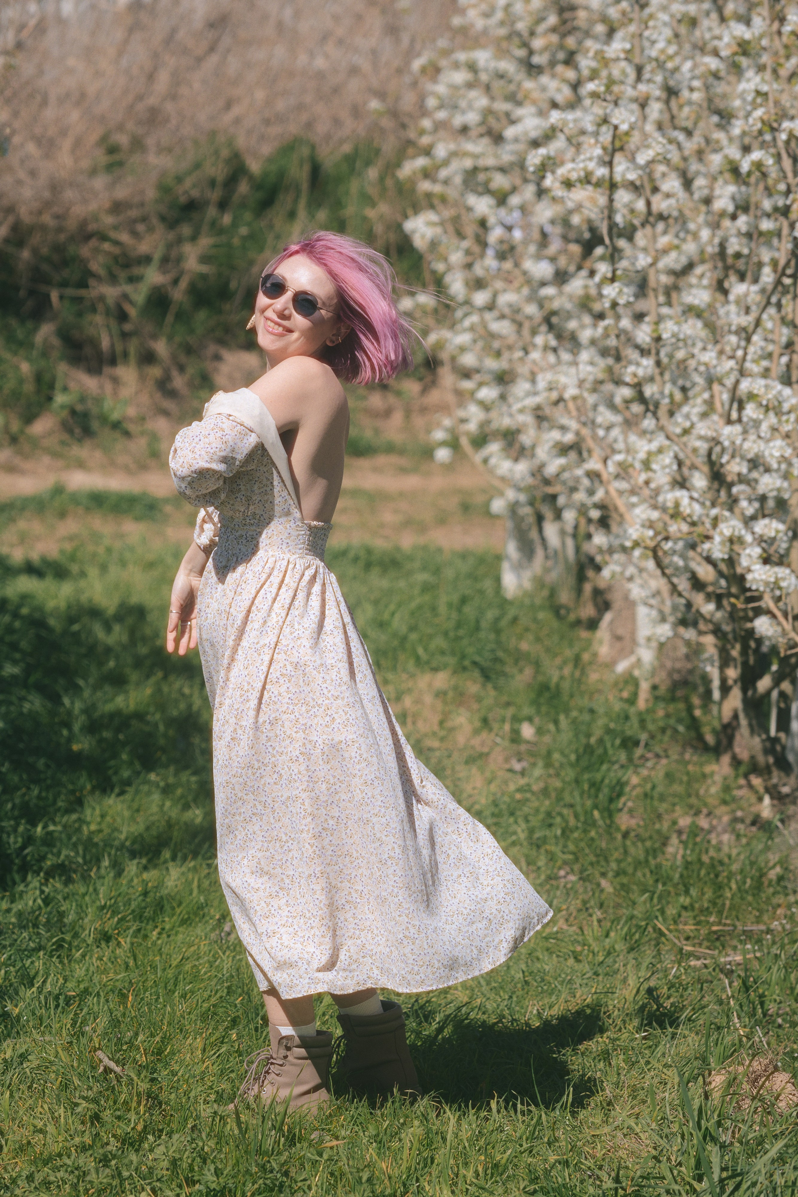 Stylish woman in a dress among flowering trees, outdoor photoshoot in Barcelona