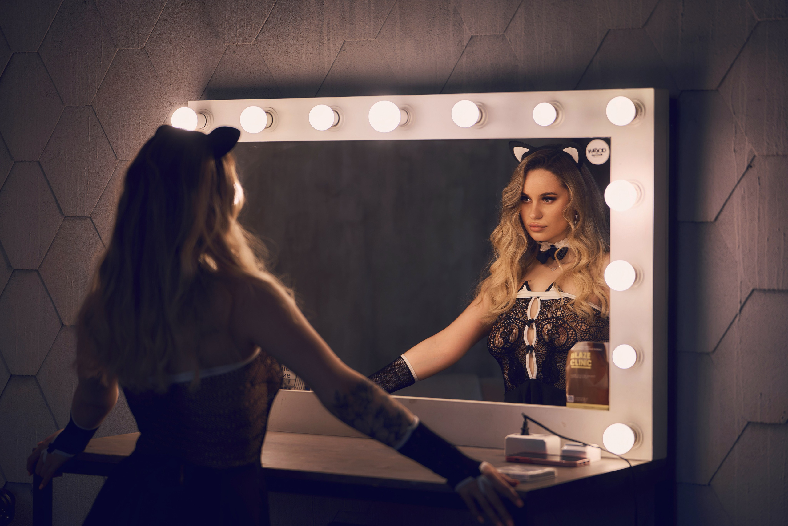 девушка в костюме кошки у зеркала в студии