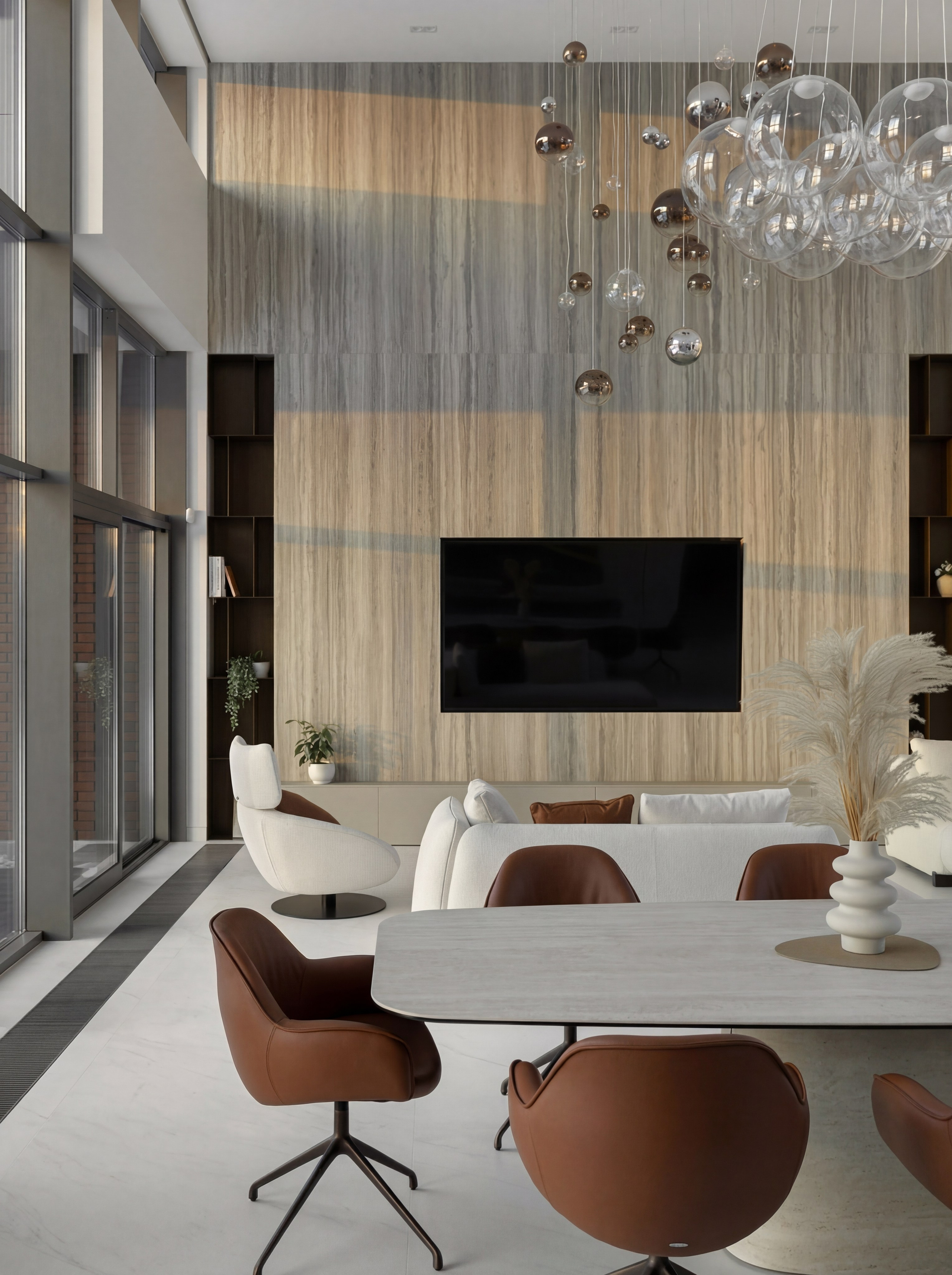 Дизайн двухсветной гостиной от Валерии Котович: высокая акцентная стена из камня с ТВ-панелью, панорамное остекление, обеденный стол с терракотовыми креслами и каскадная люстра-шары в современном доме у воды.