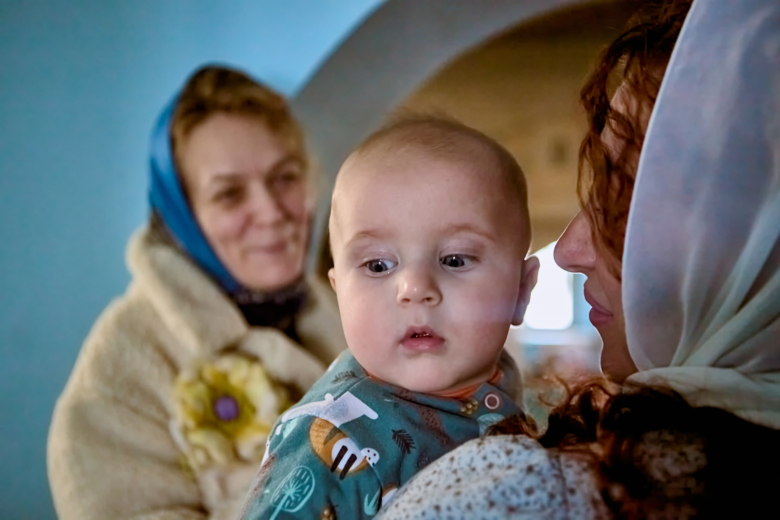 Малышка на руках у мамы смотрин за спину 