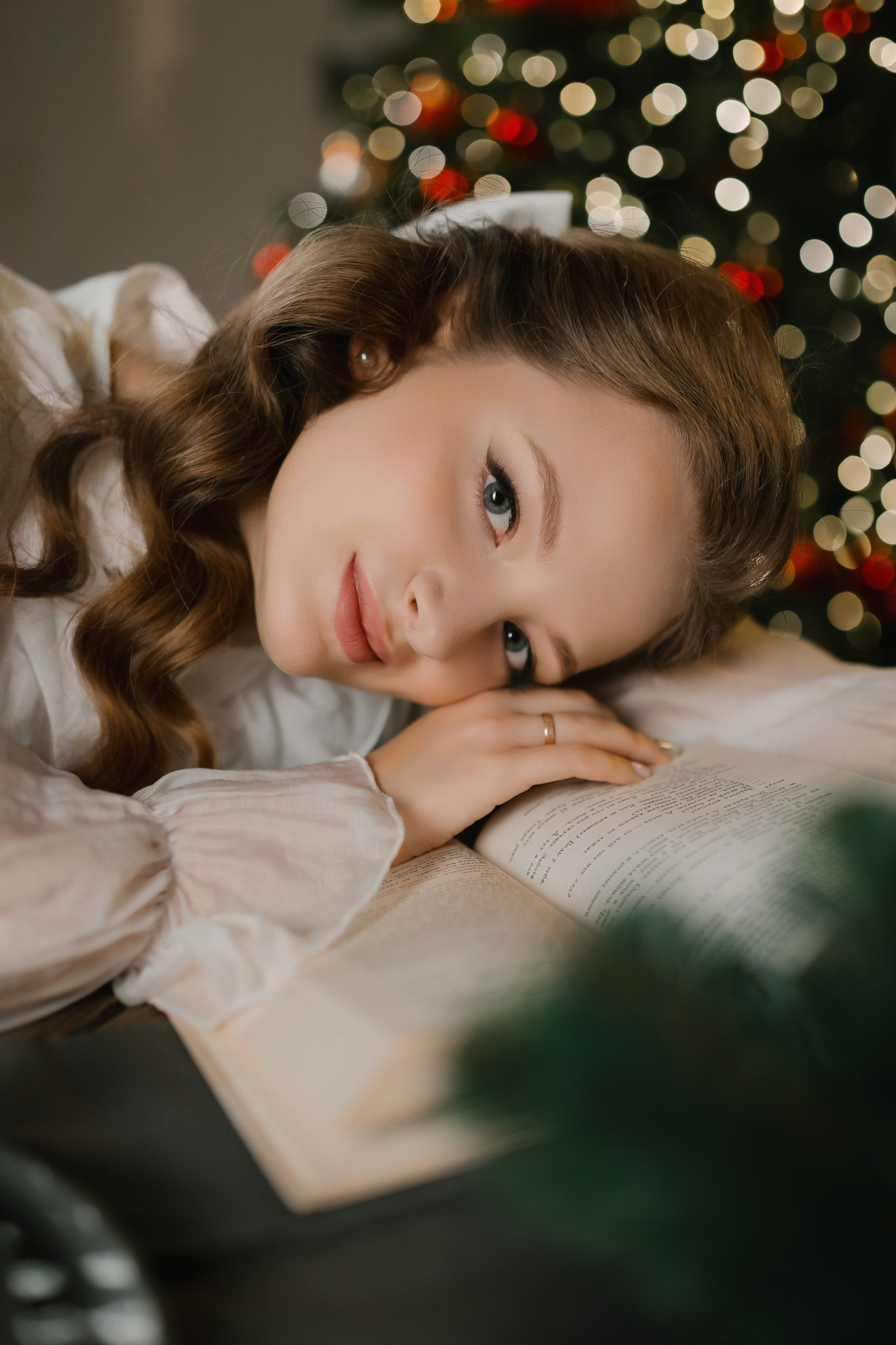 Сидя боком на скамье или табуретке около огня, поворачивается лицом к фотографу с легким наклоном головы.