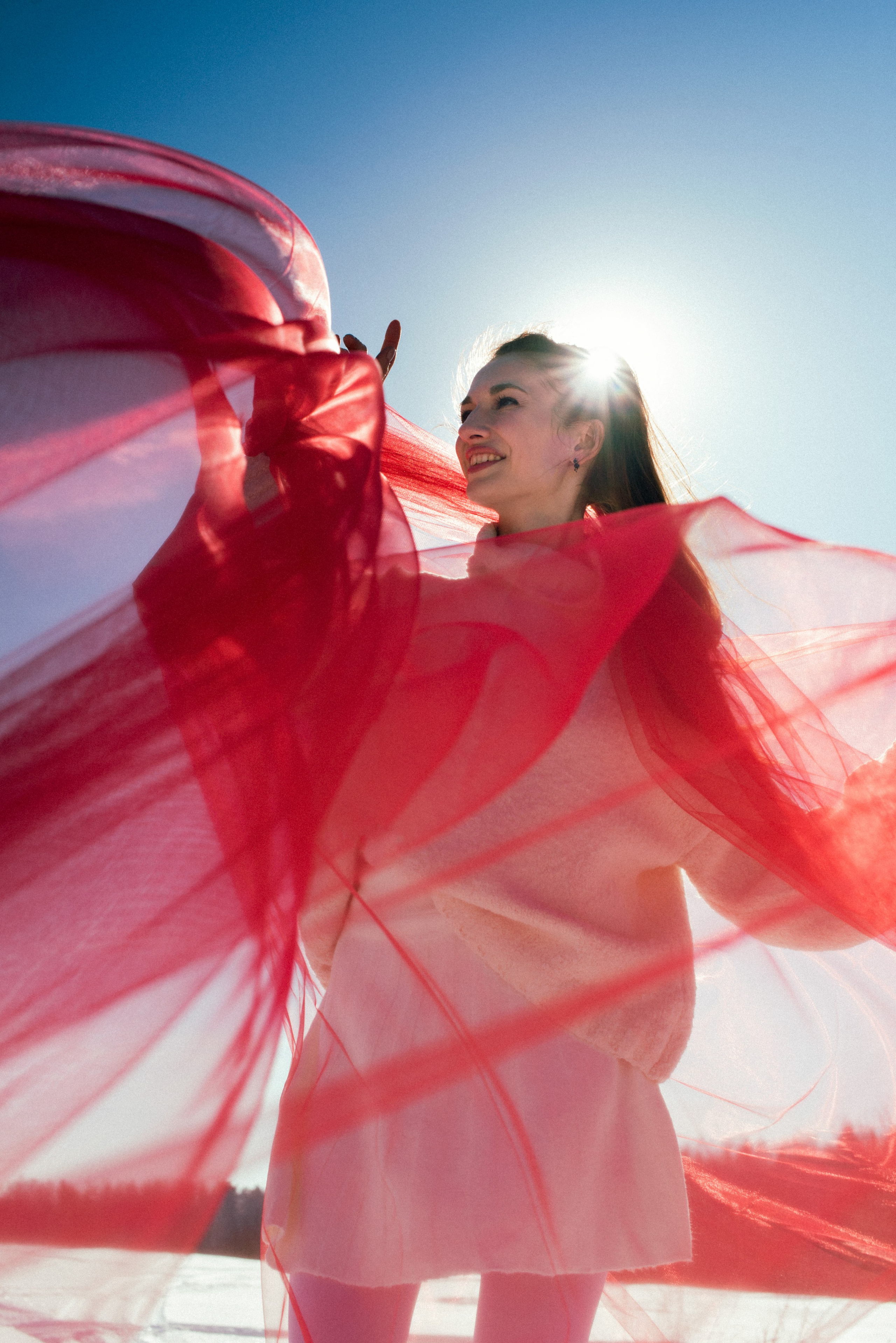 Зимняя фотосессия в Гребнево: девушка в белом свитере с красным фатином.