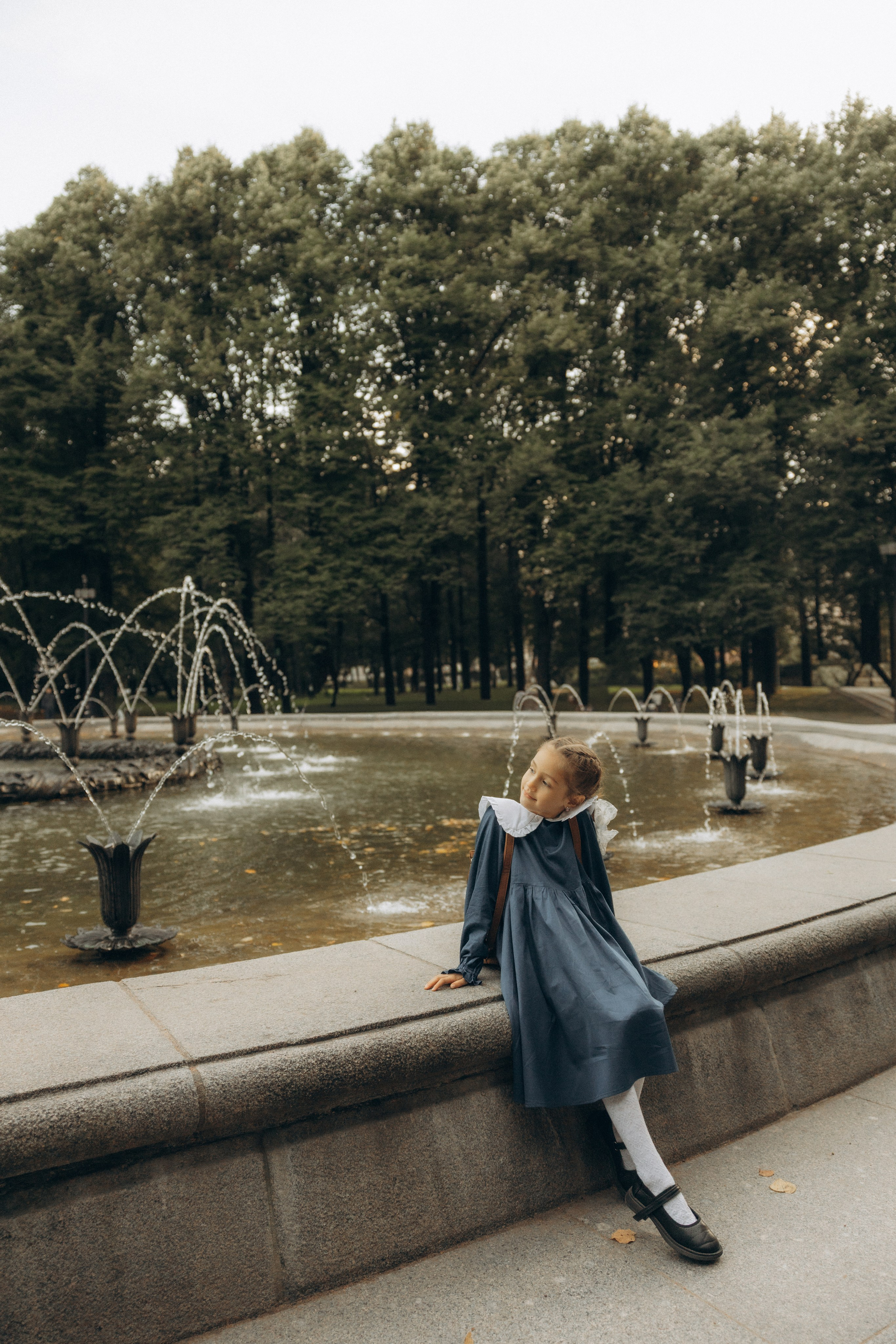 Первоклашка гуляет возле фонтана фото
