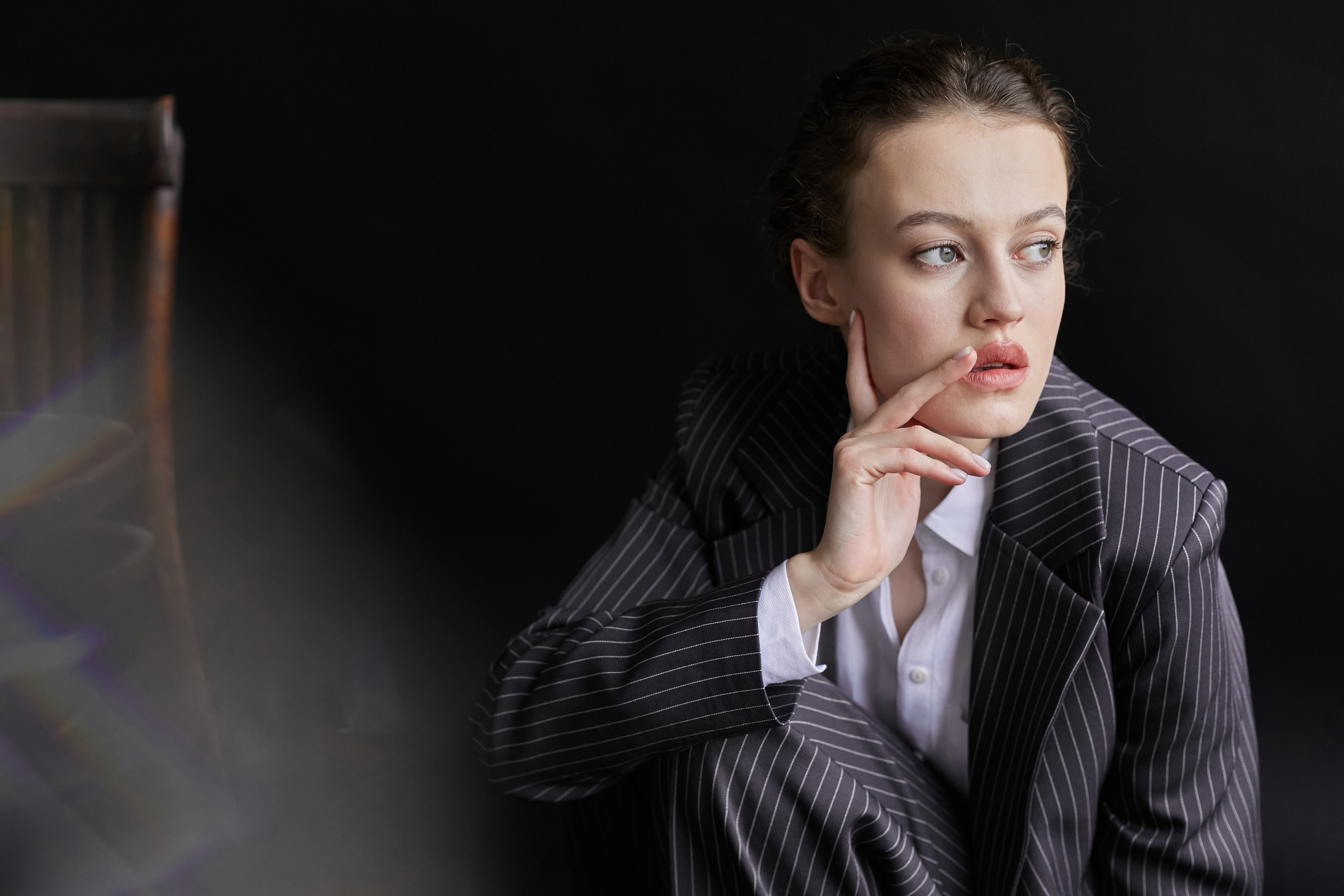 Фотограф в Москве. Студия. Студийный портрет. Девушка в пиджаке. Девушка на стуле на черном фоне. Красивая девушка в мужском костюме. Женский портрет.