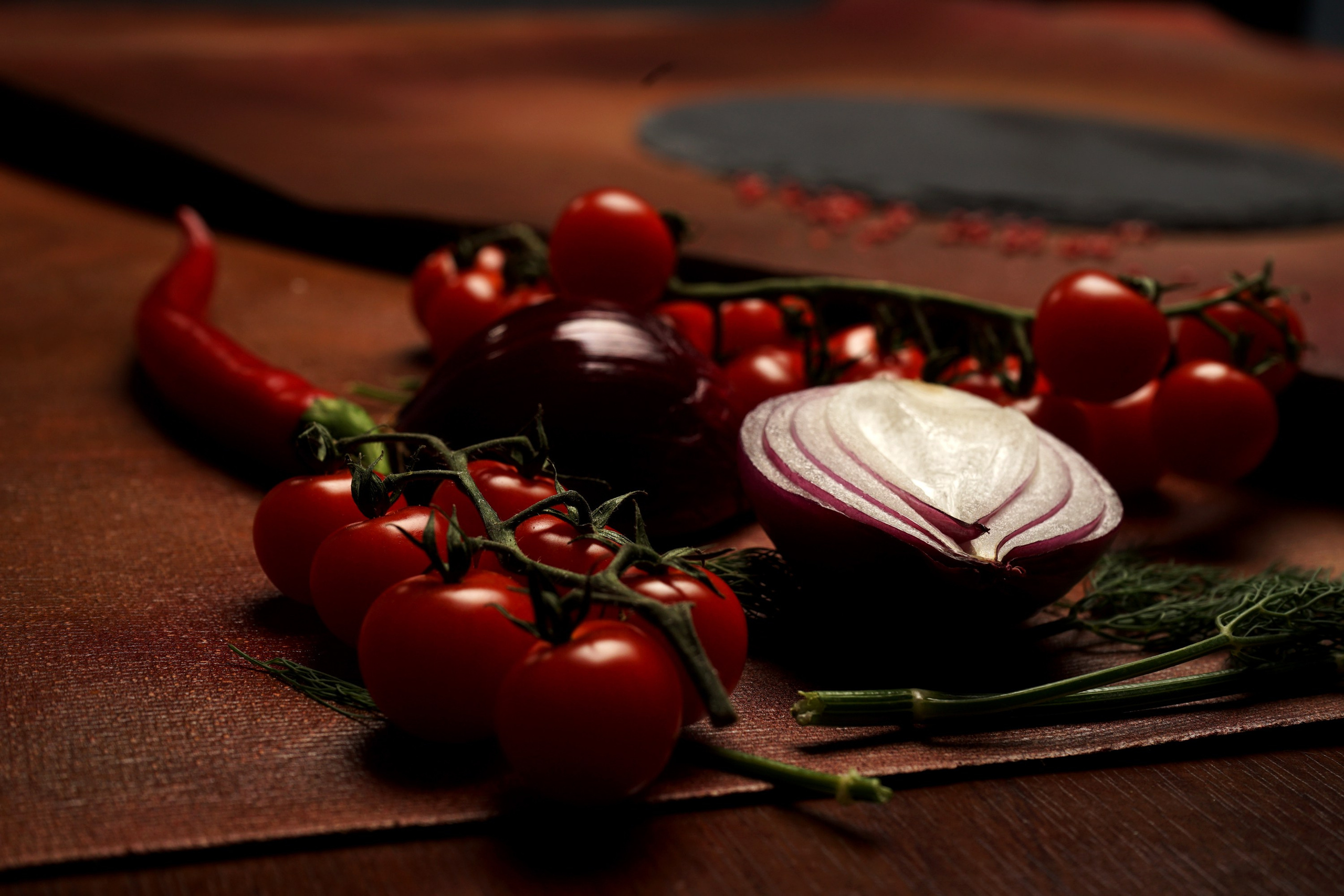 Натюрморт из помидоров, красного лука и зелени в тёмных тонах